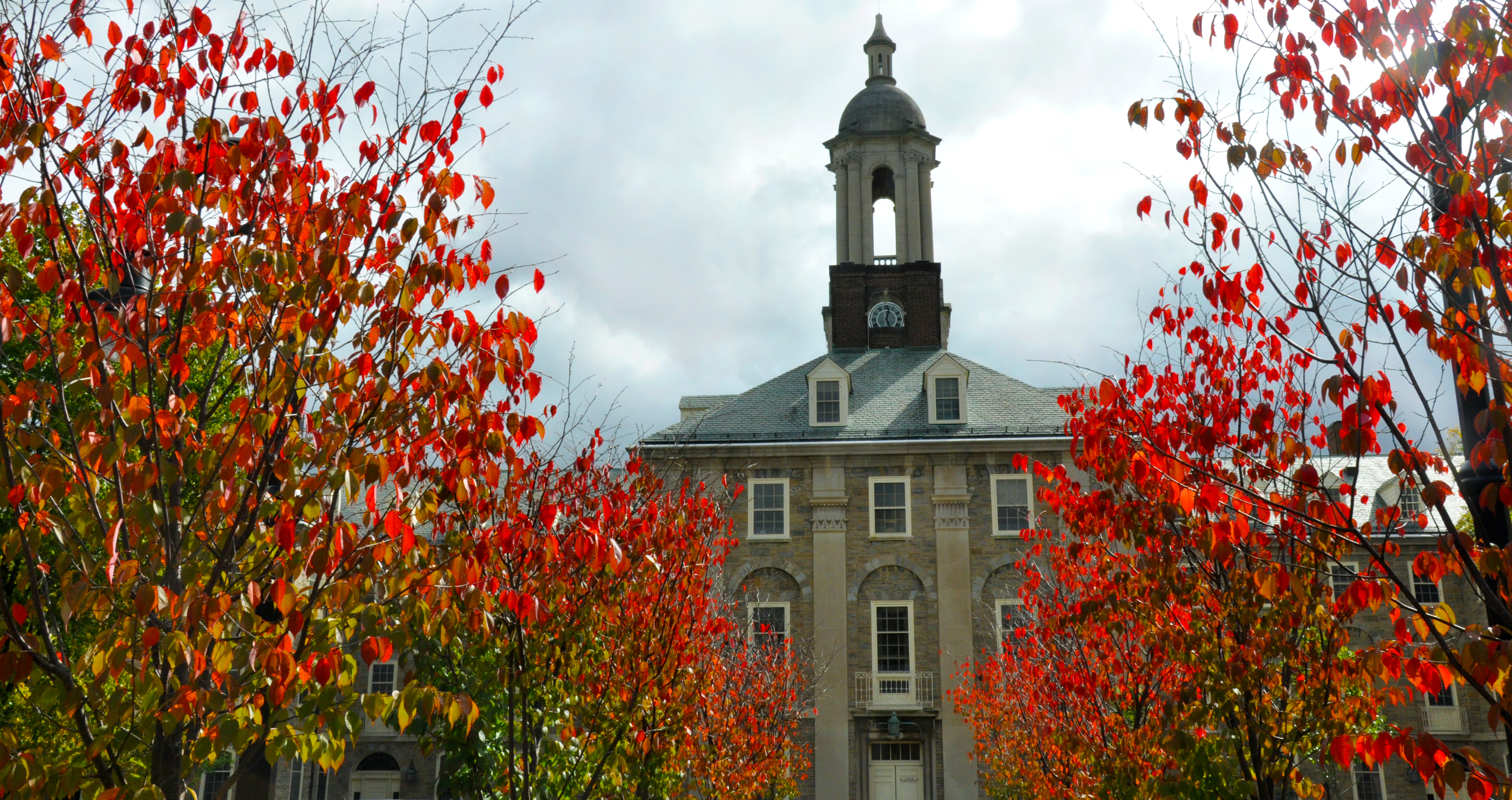 View of Old Main surrounded by red fall leaves