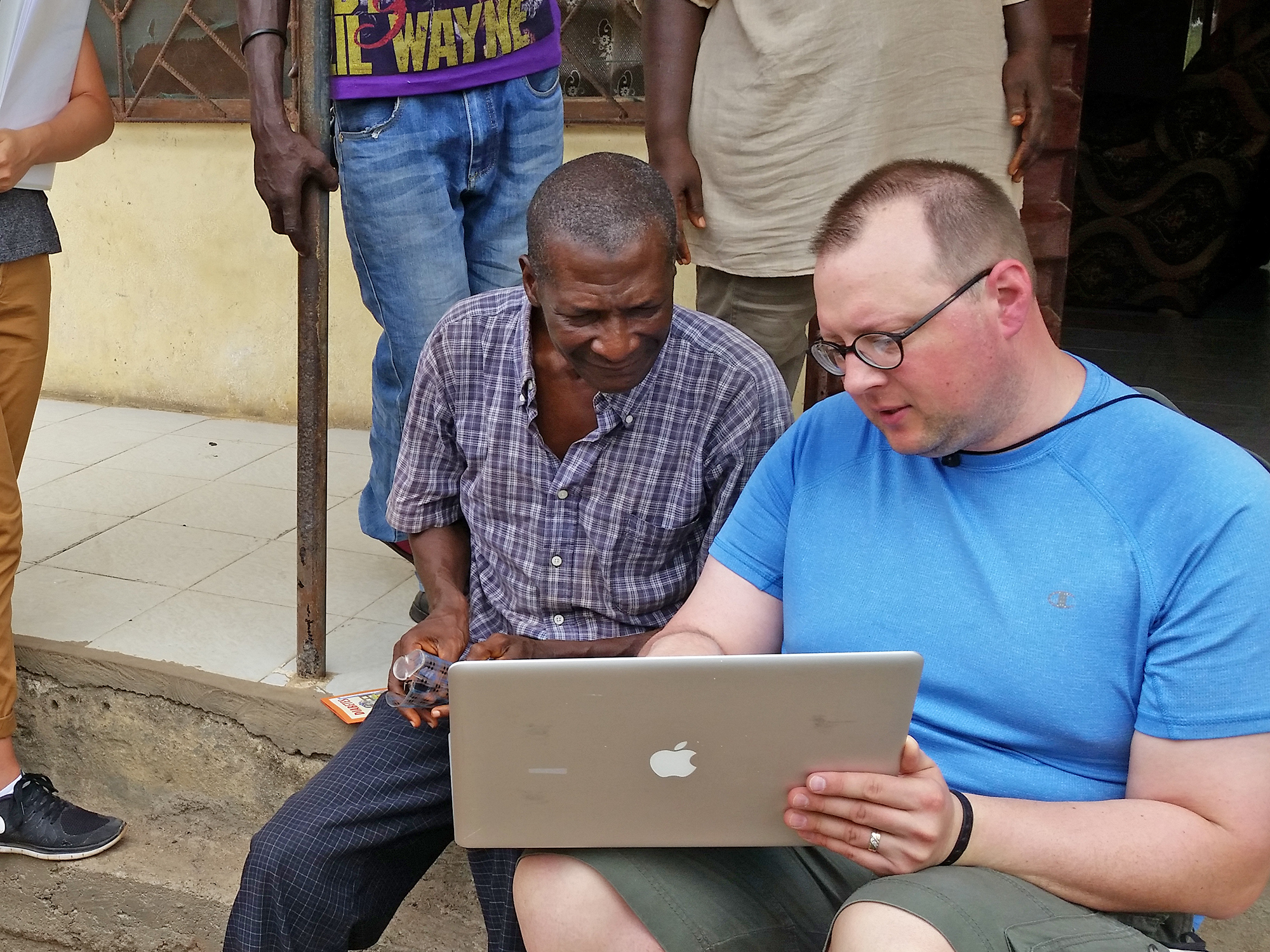 Peter Lusch shows a farmer his computer screen in Sierra Leone. 