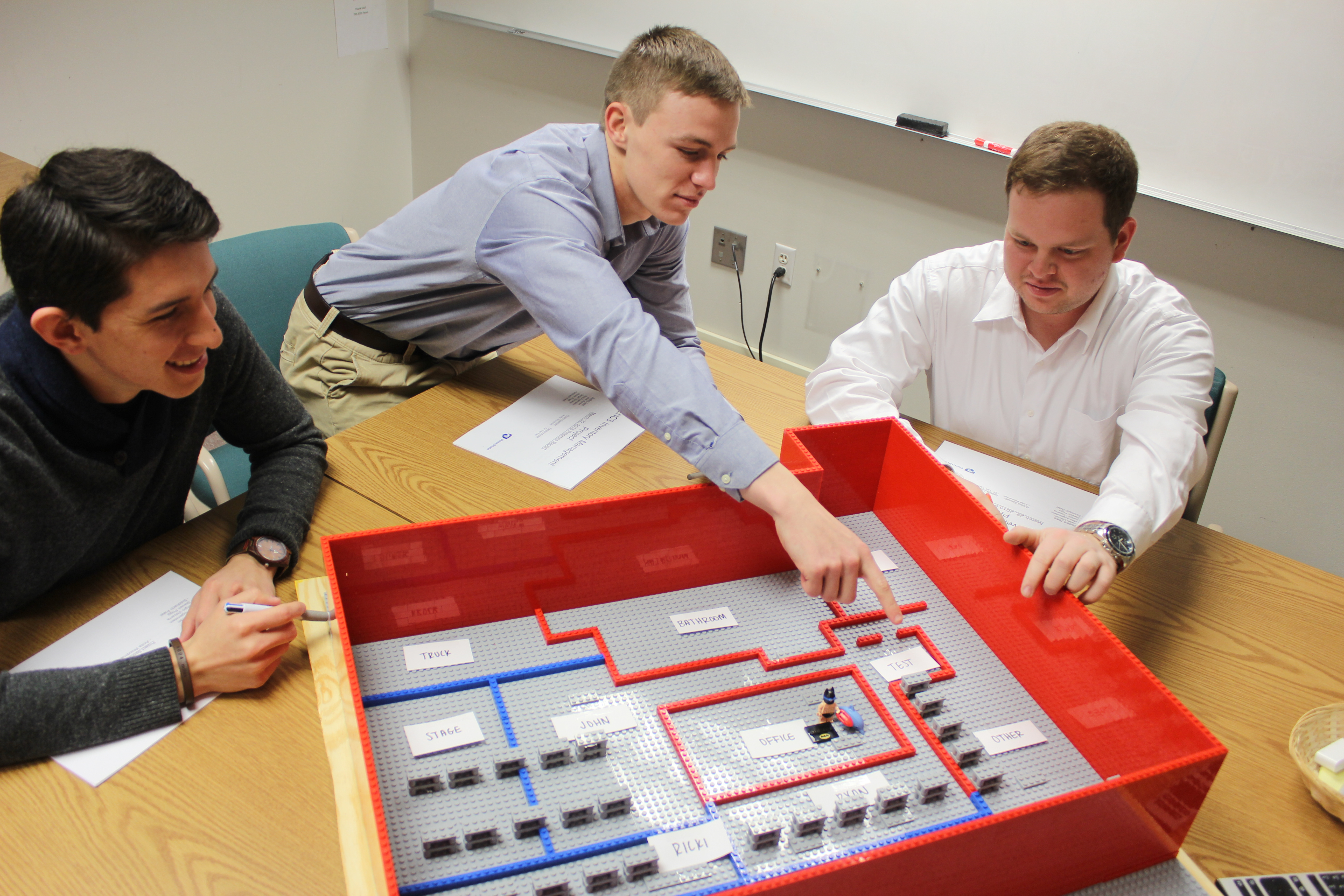 Sergio Viscarra, Jabel Warren and Steven Prigg present their team’s LEGO model of the proposed floor layout to the ENCS inventory team at a status meeting this semester. 