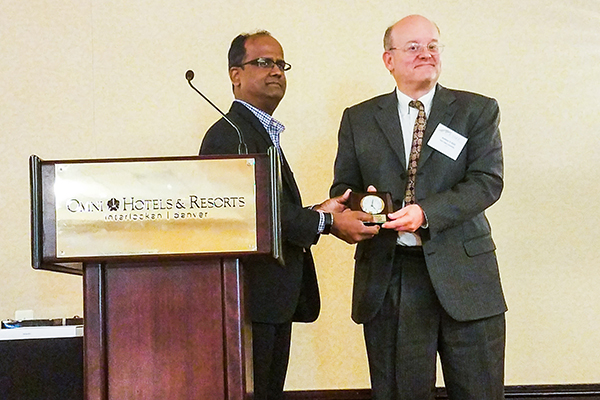 Shree Vikas, the director of Market Intelligence & Business Analysis at ConocoPhillips, awards Andy Kleit the USAEE Senior Fellow Award at the USAEE annual conference in Denver, Colorado.