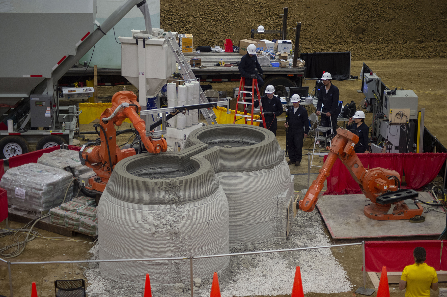 A 3D-printed concrete housing structure as it is being built with Penn State researchers observing the process.