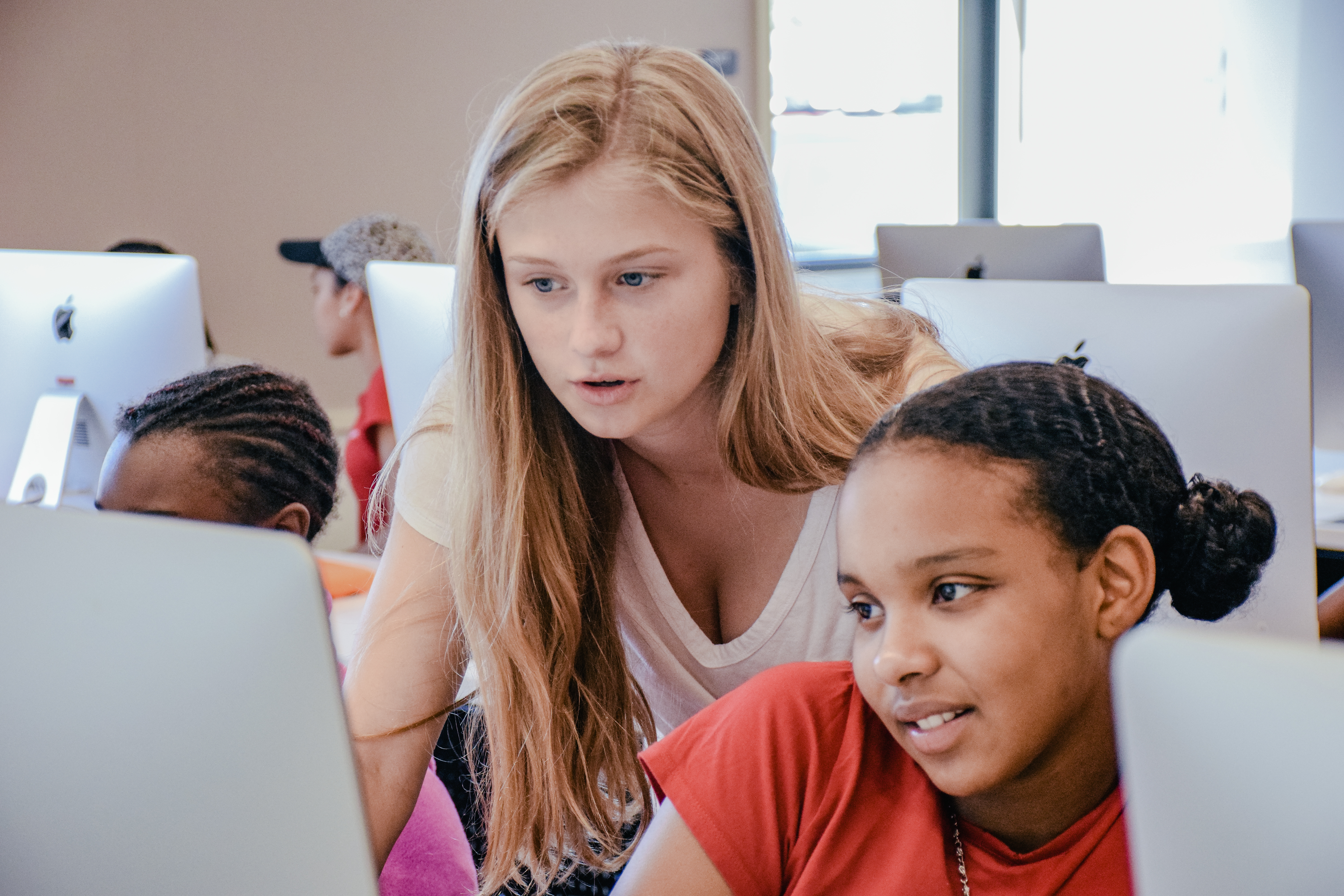 Sydney Gibbard teaches a girl in front of computer screen