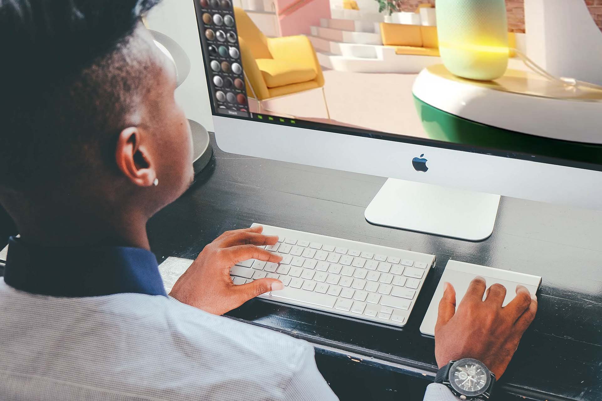 a man sitting at a computer using an adobe substance app