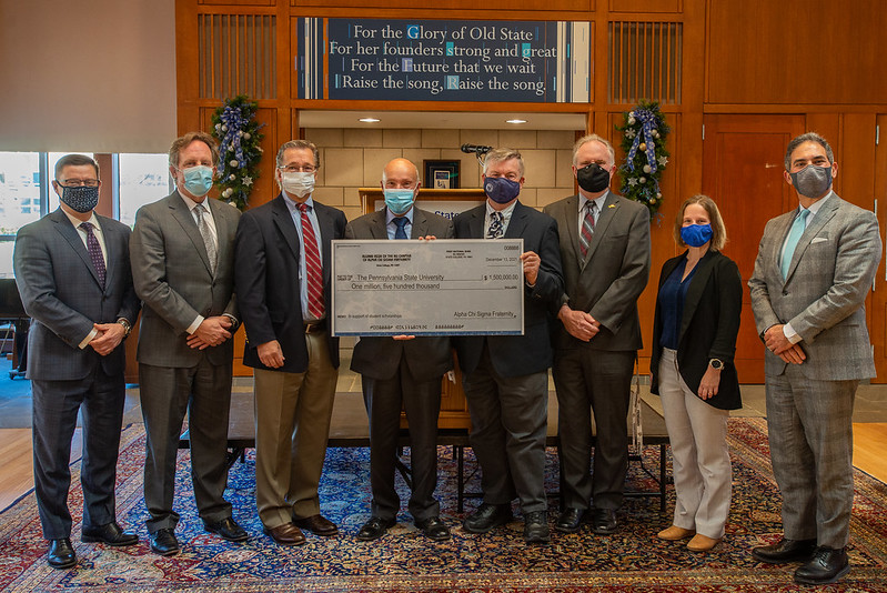 A group of people pose for a photograph with a ceremonial check