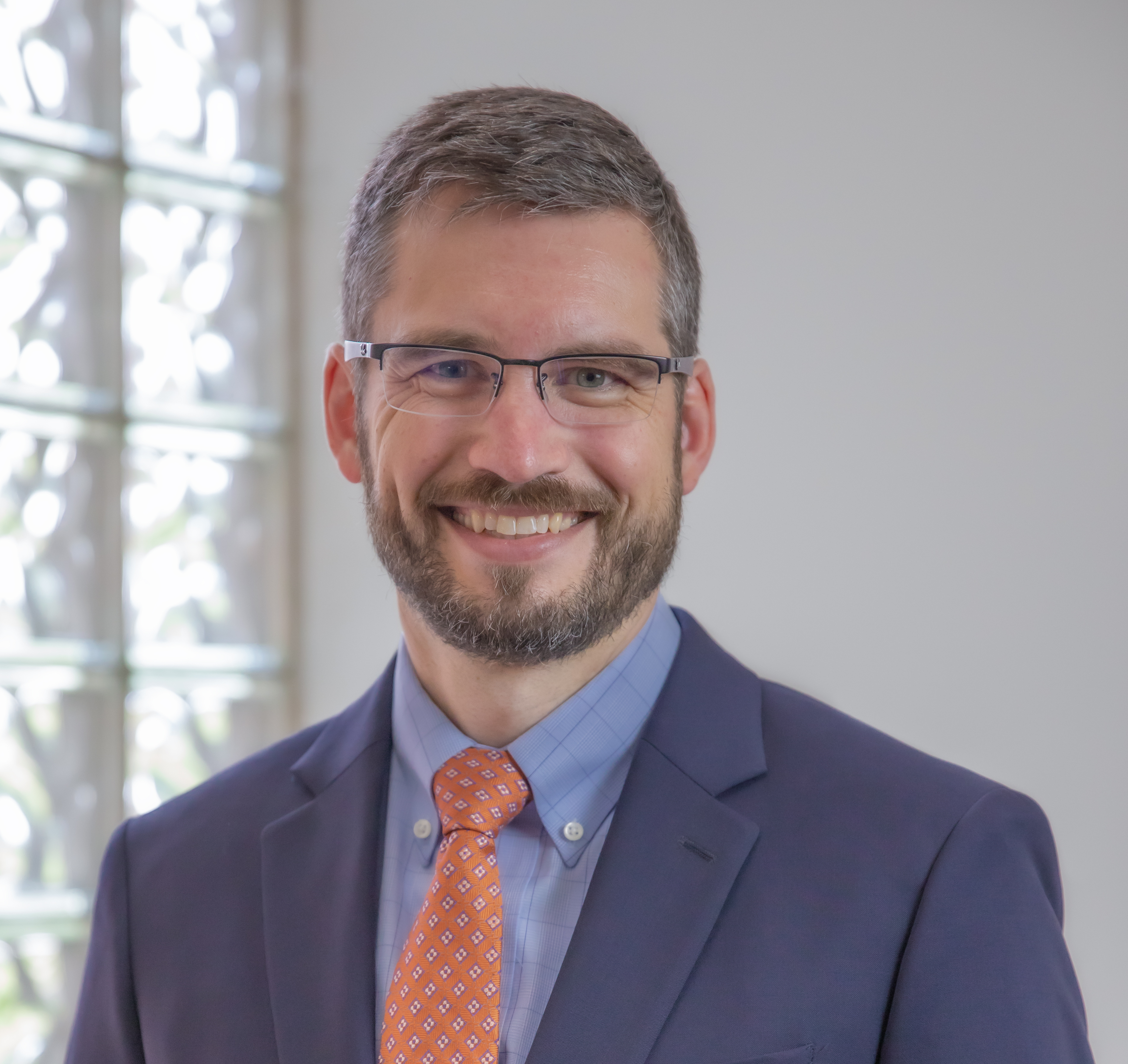 Man smiles in suit for headshot photo