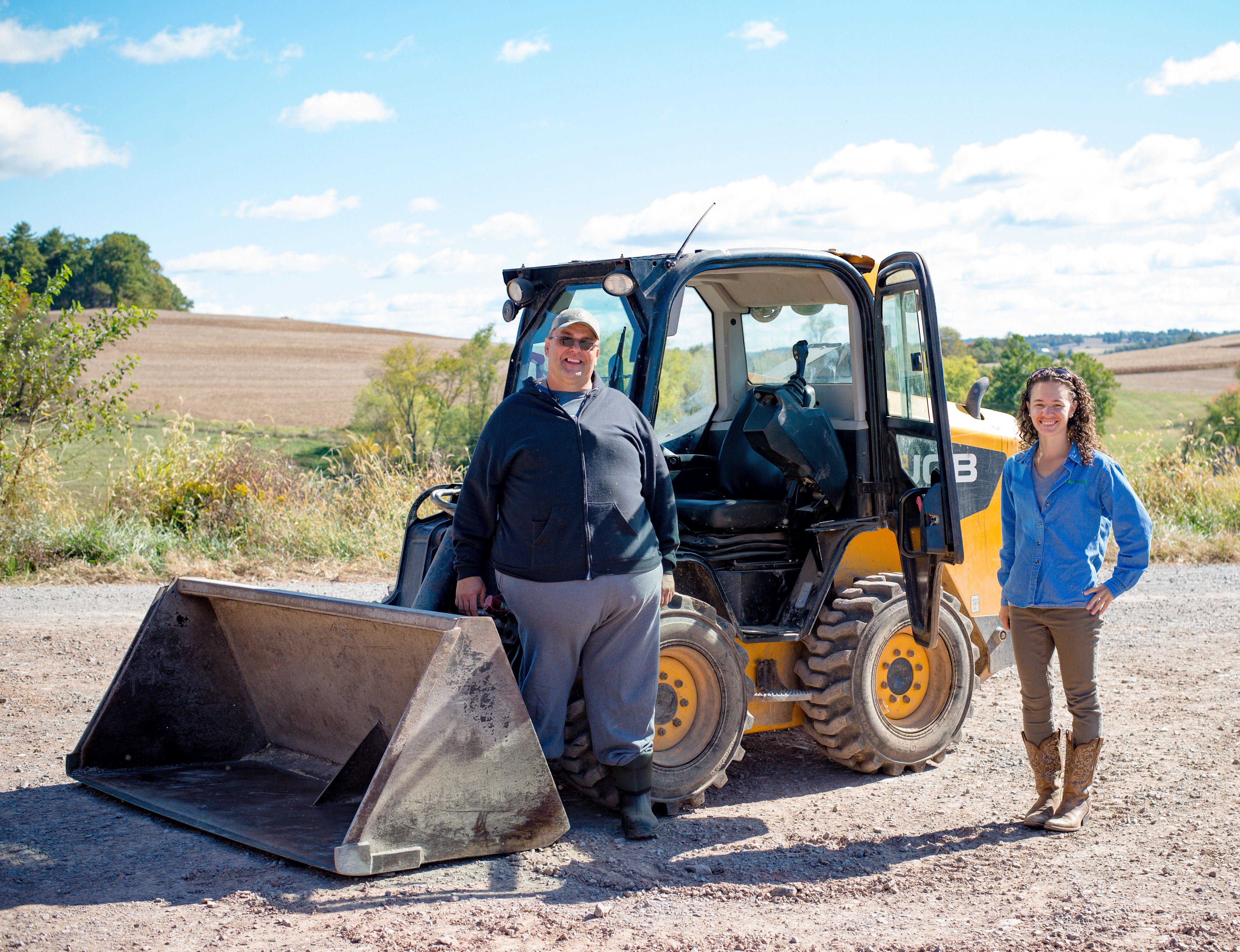 Farmer Garvin Schaffer, AgrAbility's Abbie Spackman pose with skid steer loader