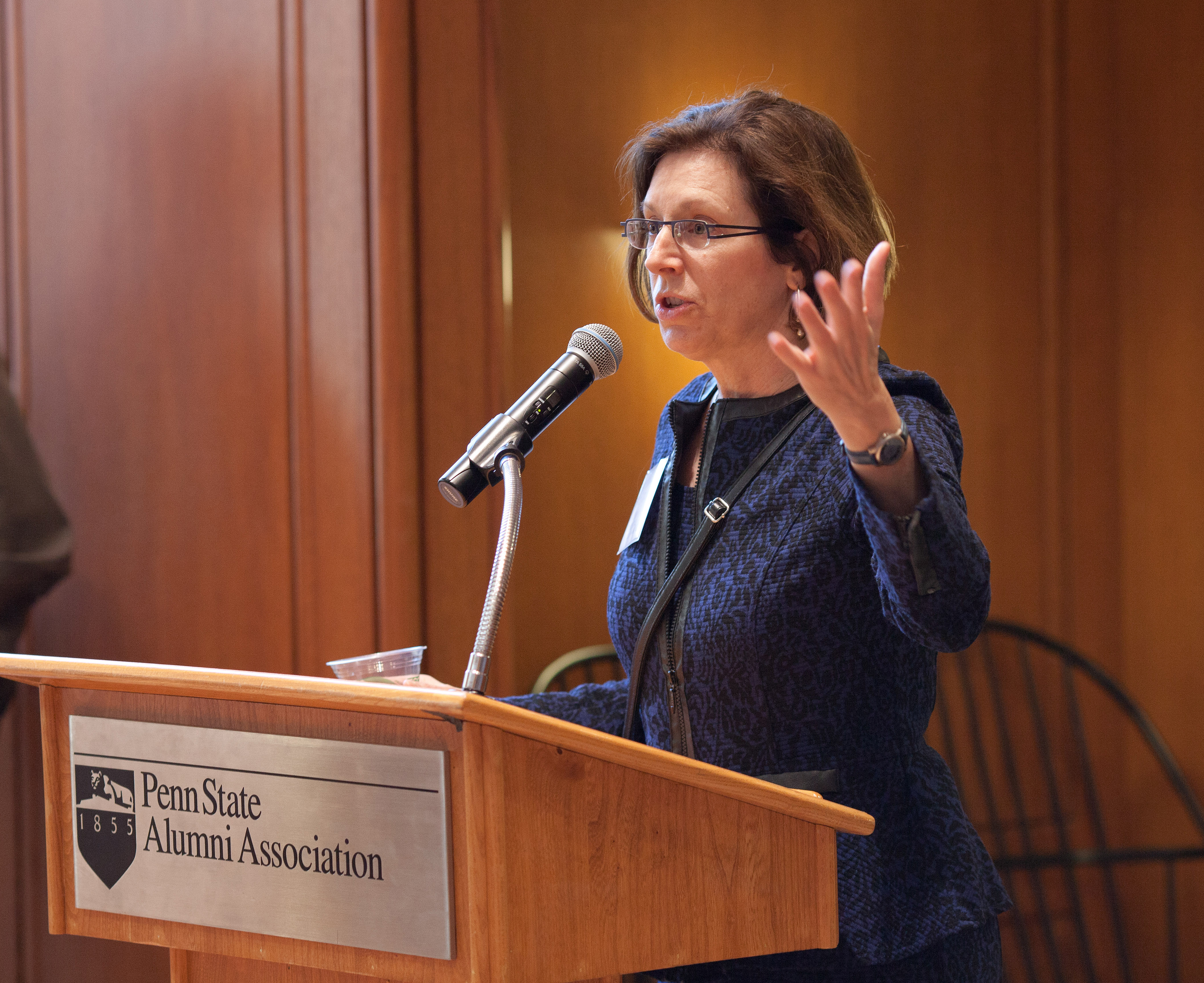 Kelleann Foster speaks at a podium featuring the Penn State Alumni Association logo.