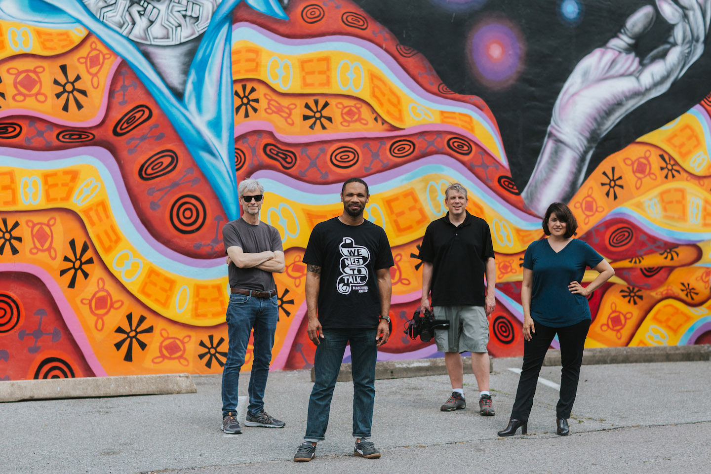 "Mending Walls" production team standing in front of mural