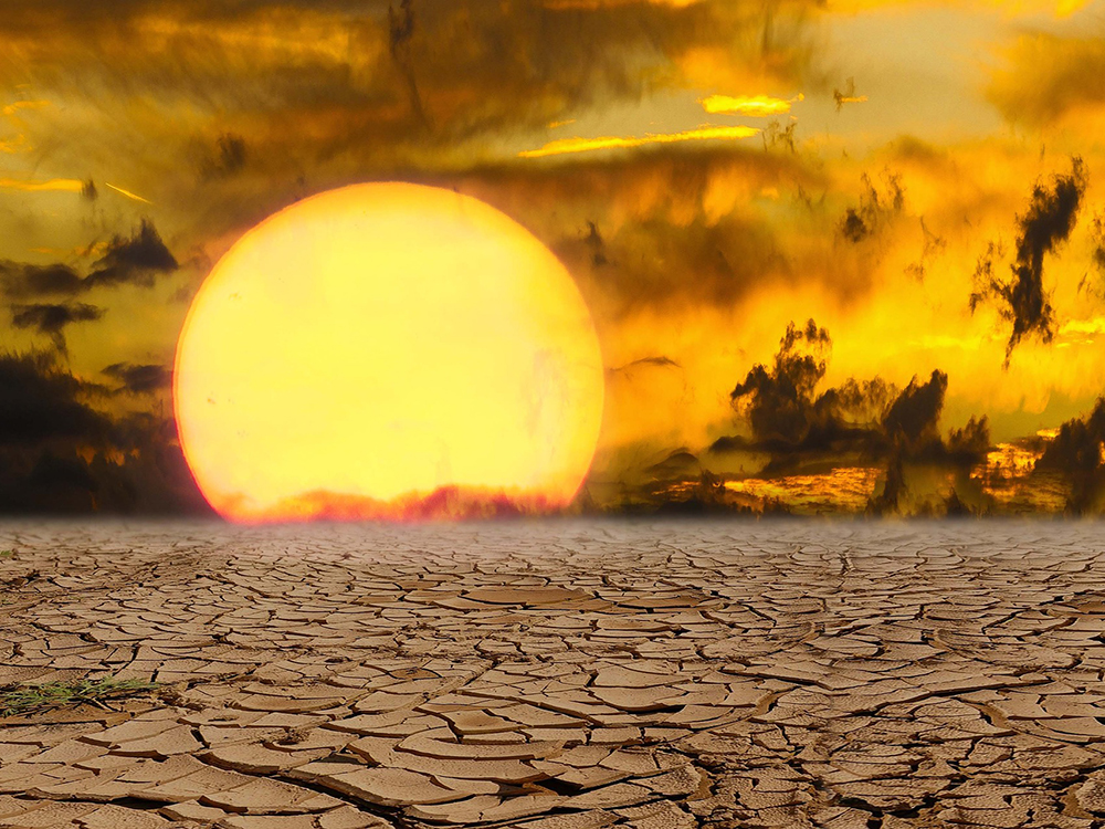 Cracked earth from drought in sunset