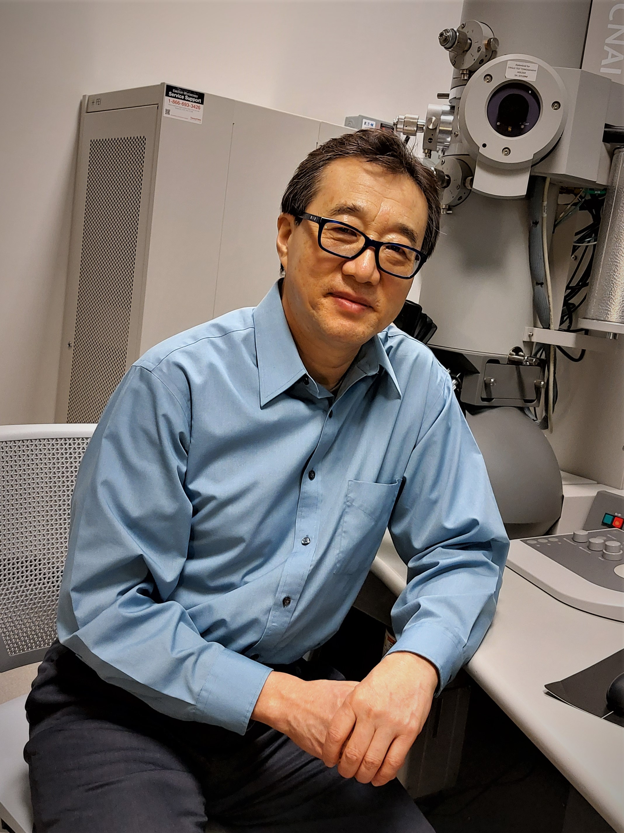 a man sits in front of a piece of scientific equipment 