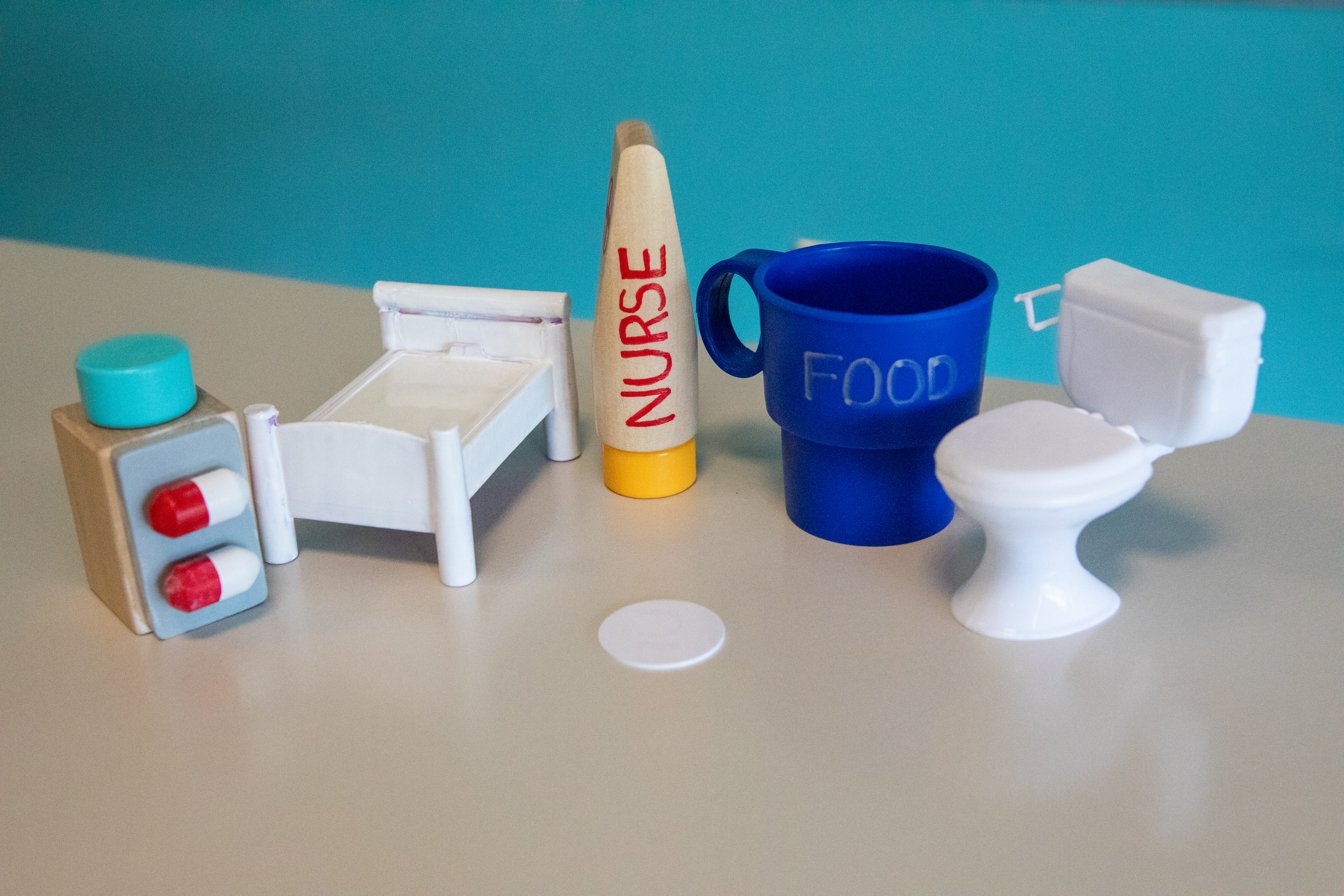 A collection of dollhouse toys represent how NCF technology could be affixed to everyday items to replace the standard call button in pediatric hospital rooms