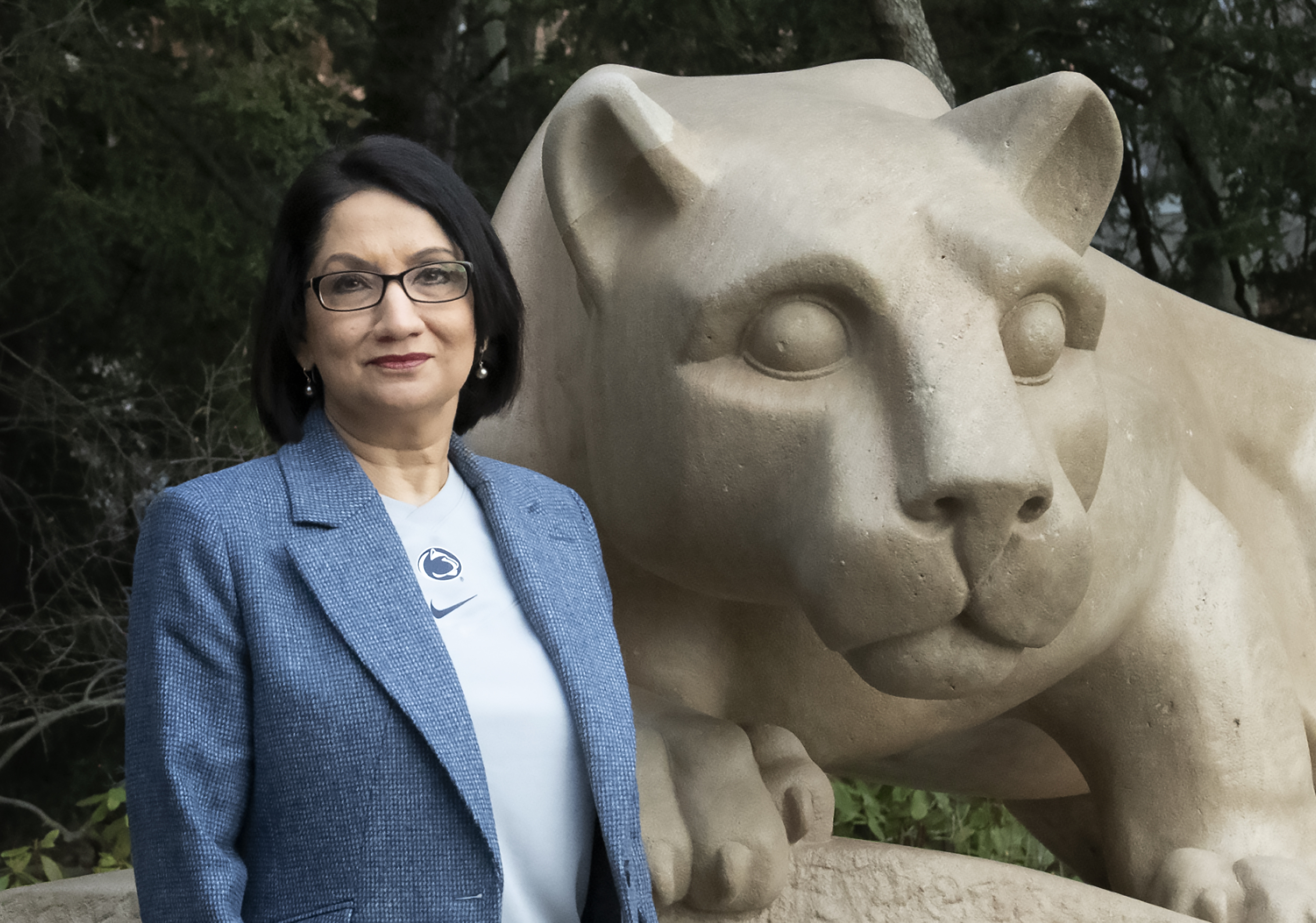 Neeli Bendapudi stands in front of stone Lion Shrine statue at Penn State.