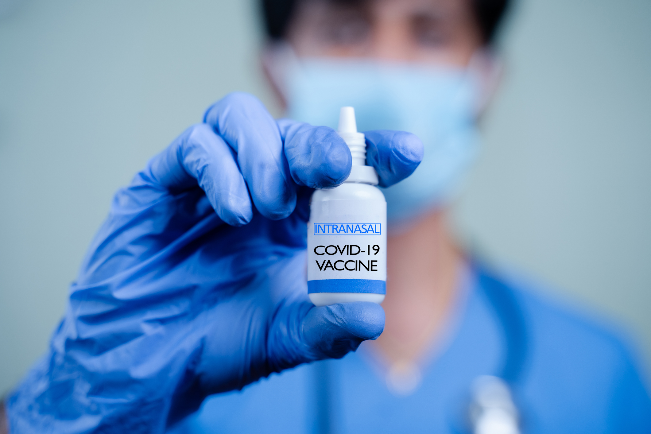 Gloved person holding vial of inhalable COVID-19 vaccine