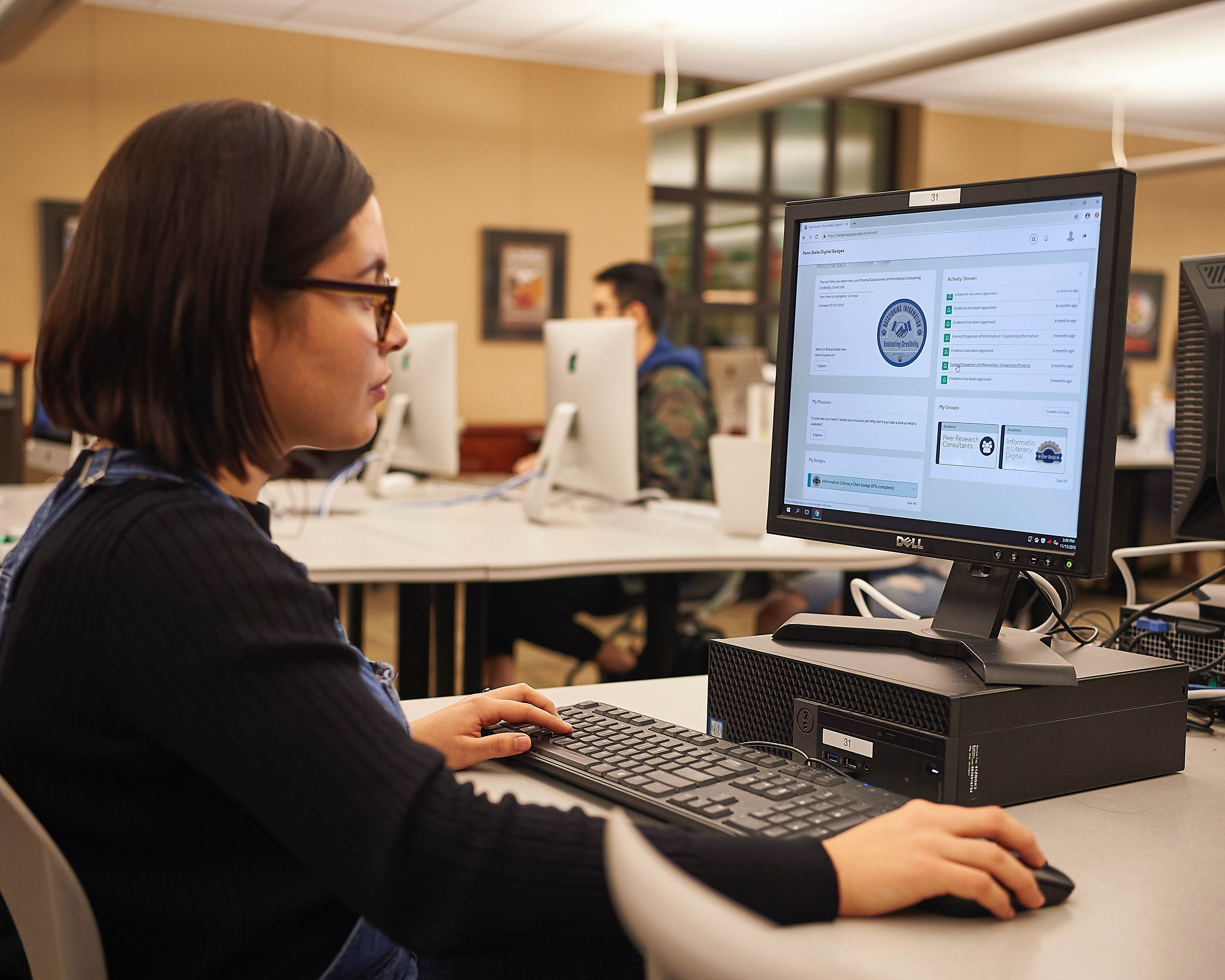 person sitting at table with hands on computer keyboard and looking at computer screen