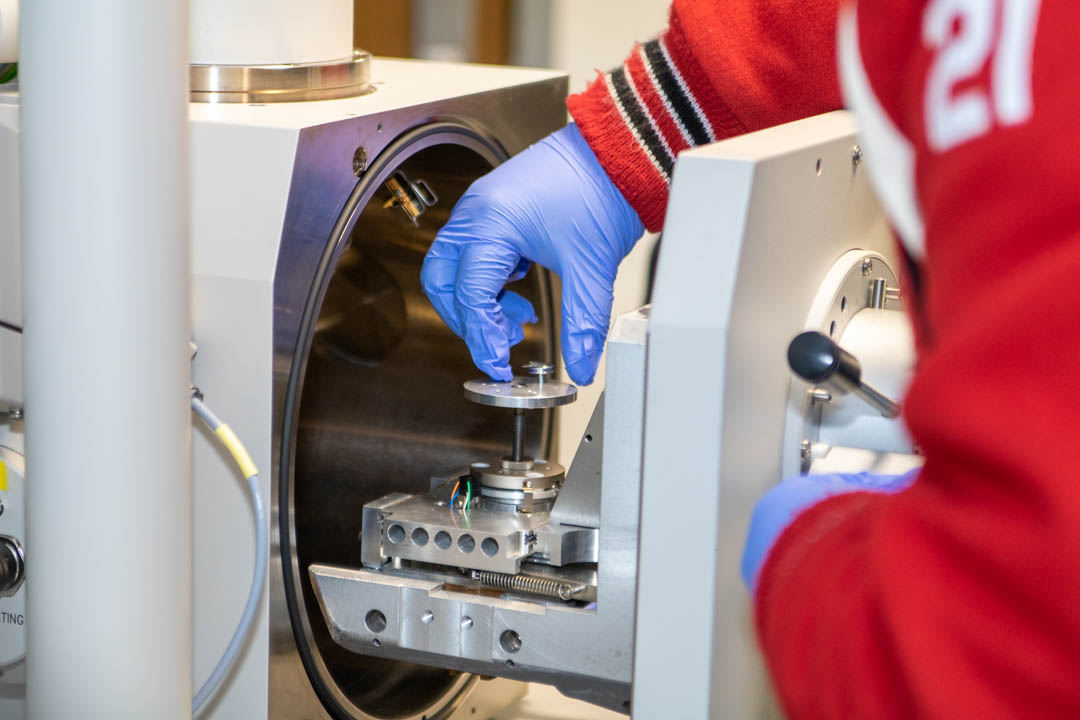 Student placing mask sample in SEM machine 