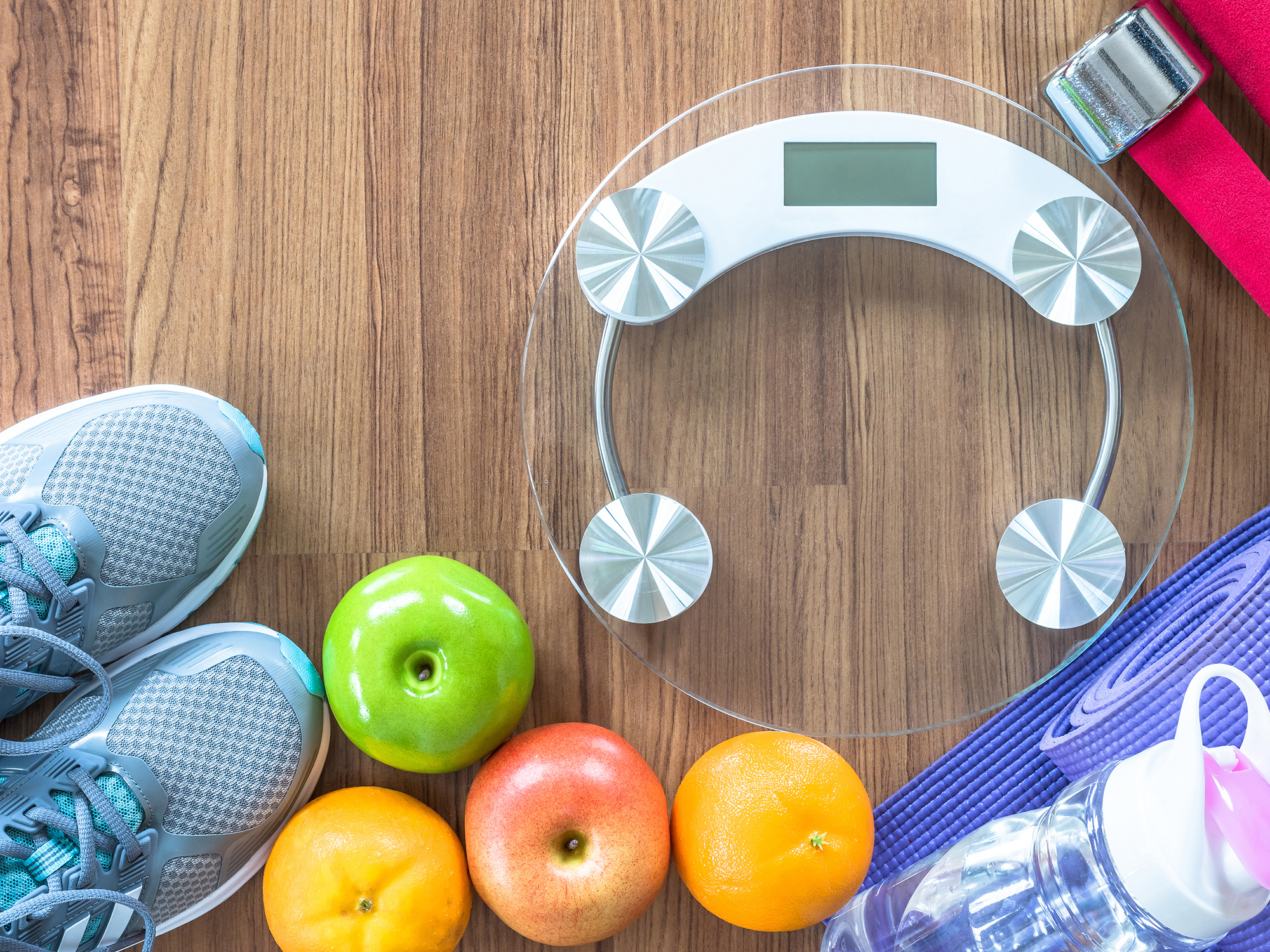 A photo promoting healthy living, including running shoes, pieces of fruit, a water bottle, and a food scale