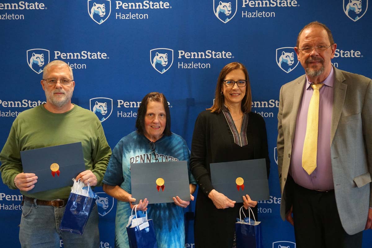 Group holding certificates and smiling.