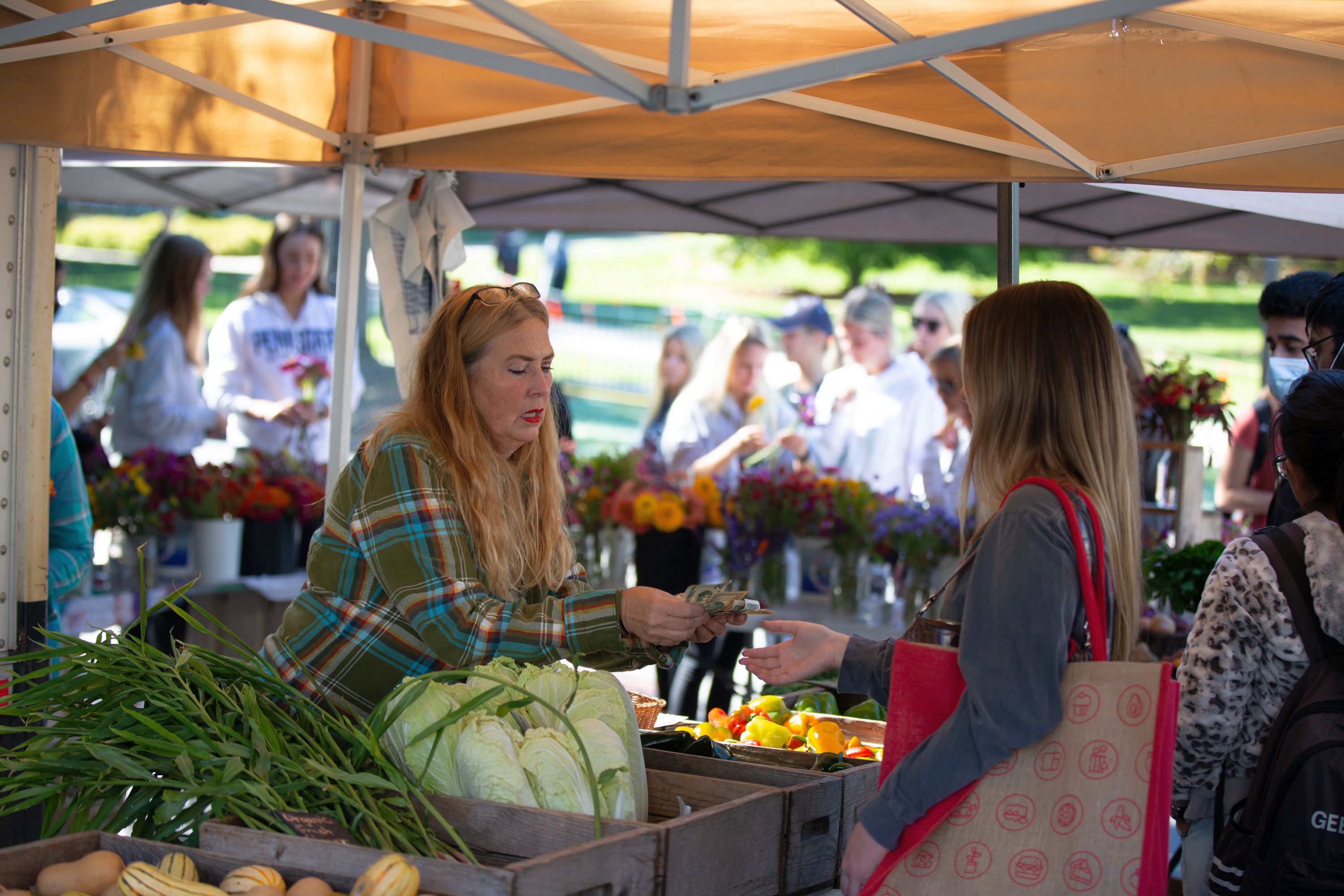 A farmers market vendor makes change for a customer