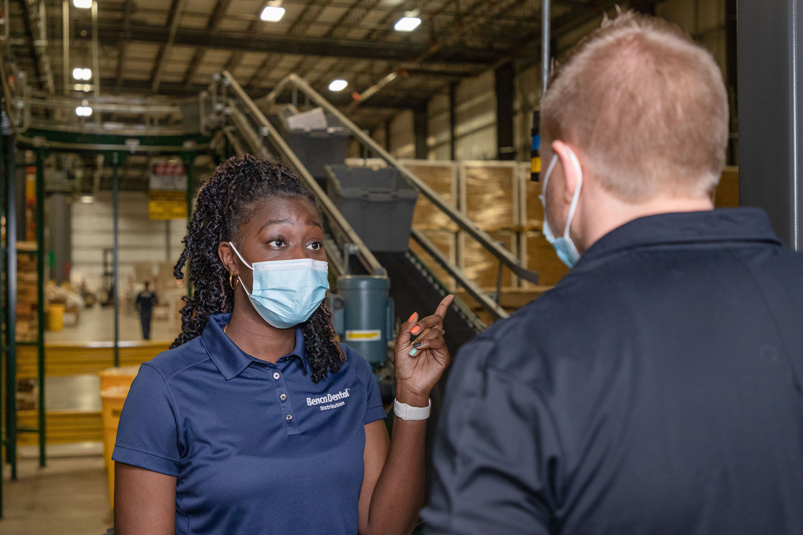 A Benco Dental employee talks to another employee.