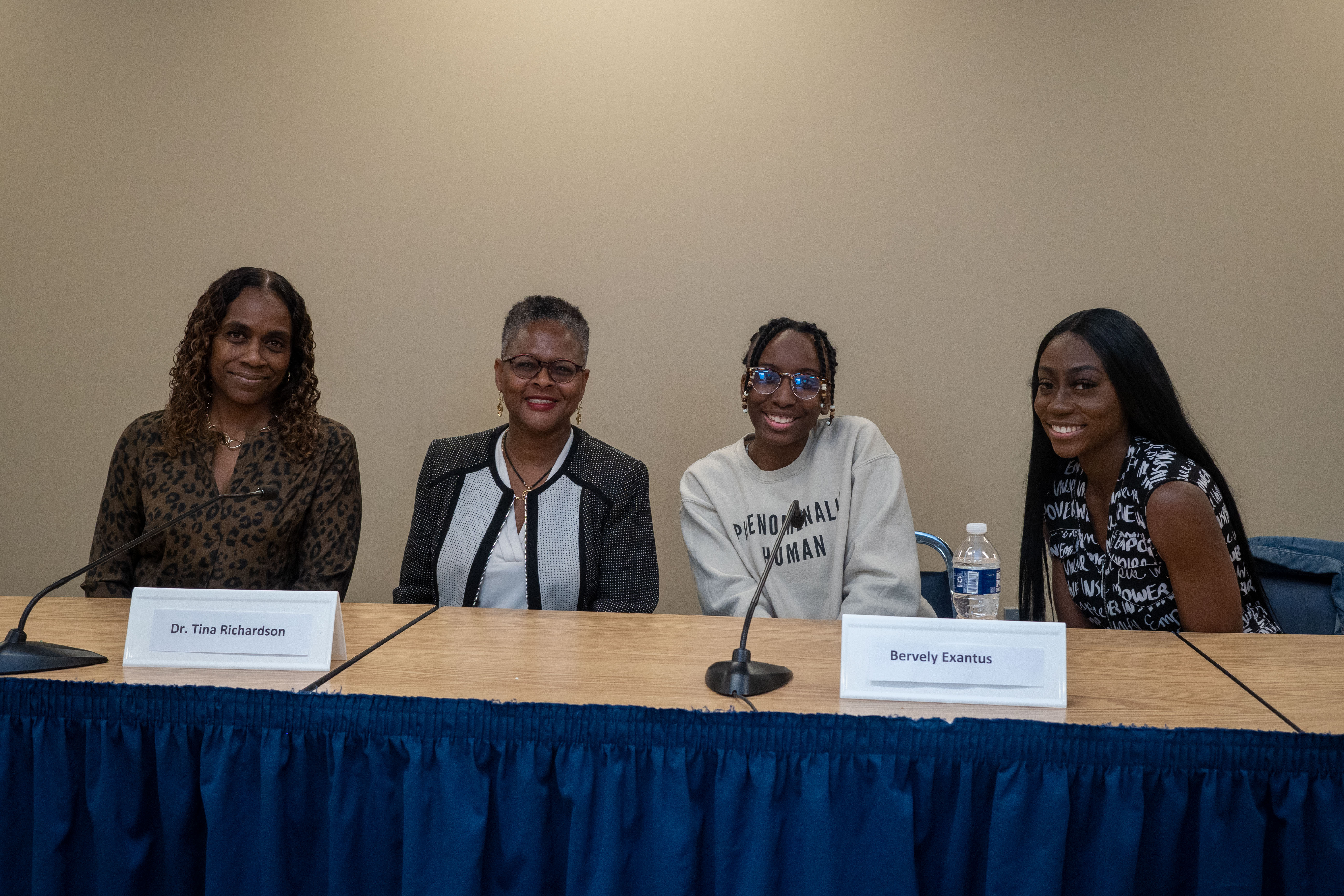 Panelists pose for pictures at table 