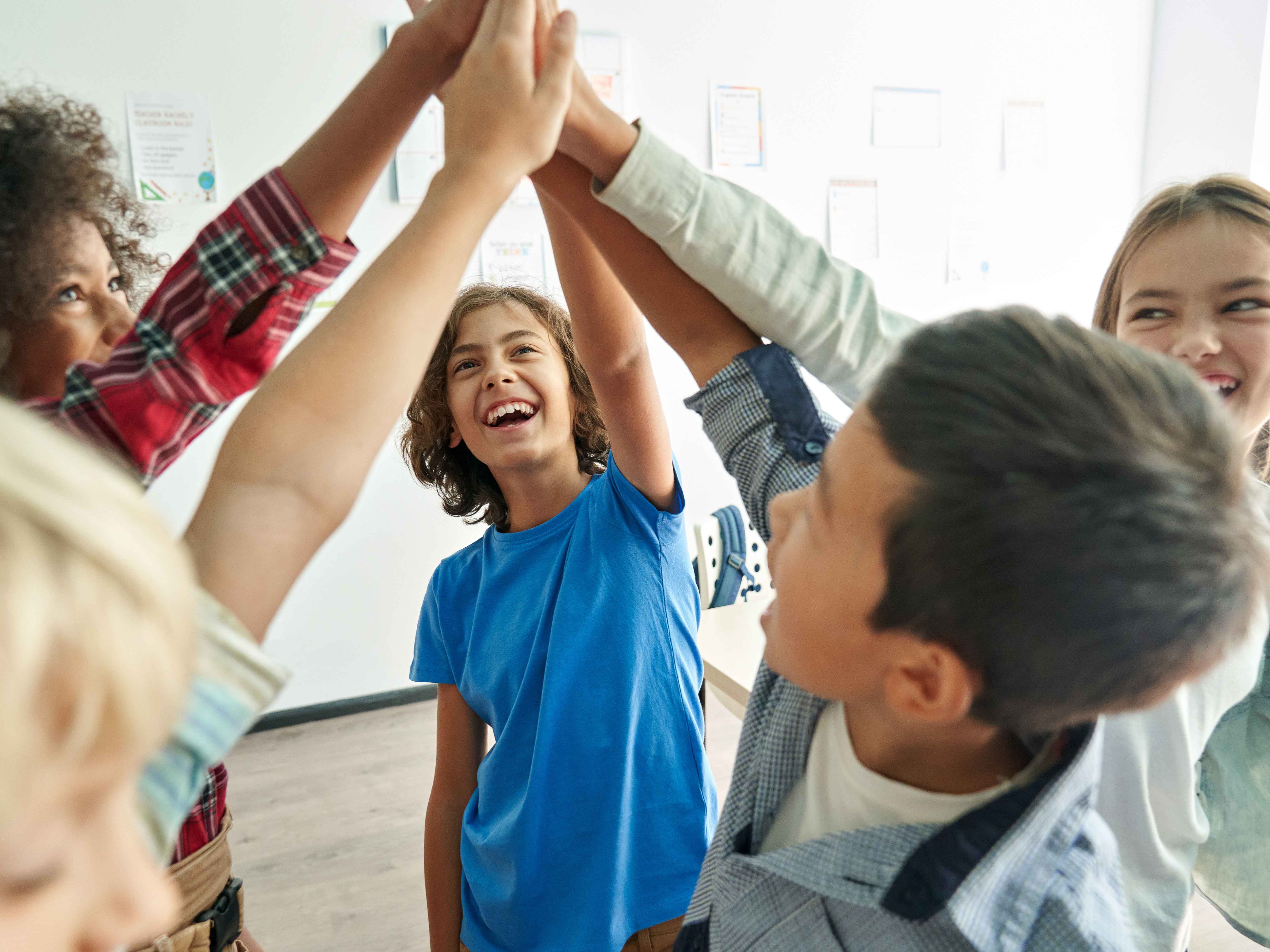 group of five teens giving each other a high five