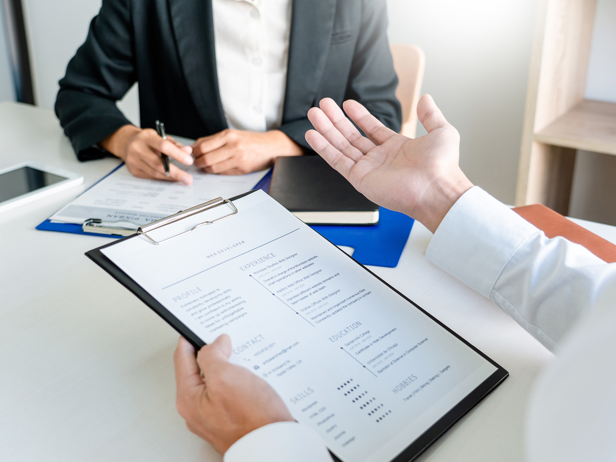 A photo of someone reviewing a resume and interviewing a prospective employee