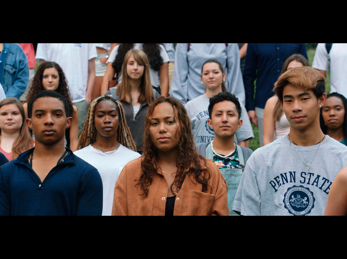 In this still from Penn State's new "Redefining Legacy" brand video, a group of students gaze at the viewer wearing serious, solemn expressions.