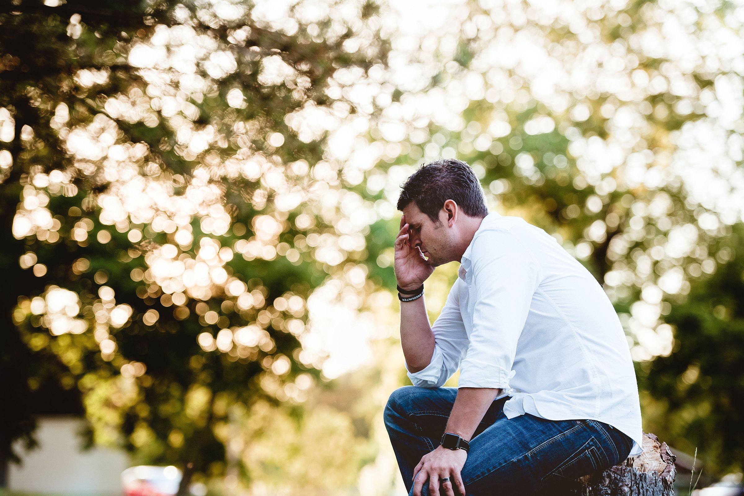 Man sitting with his face in his hand looking depressed