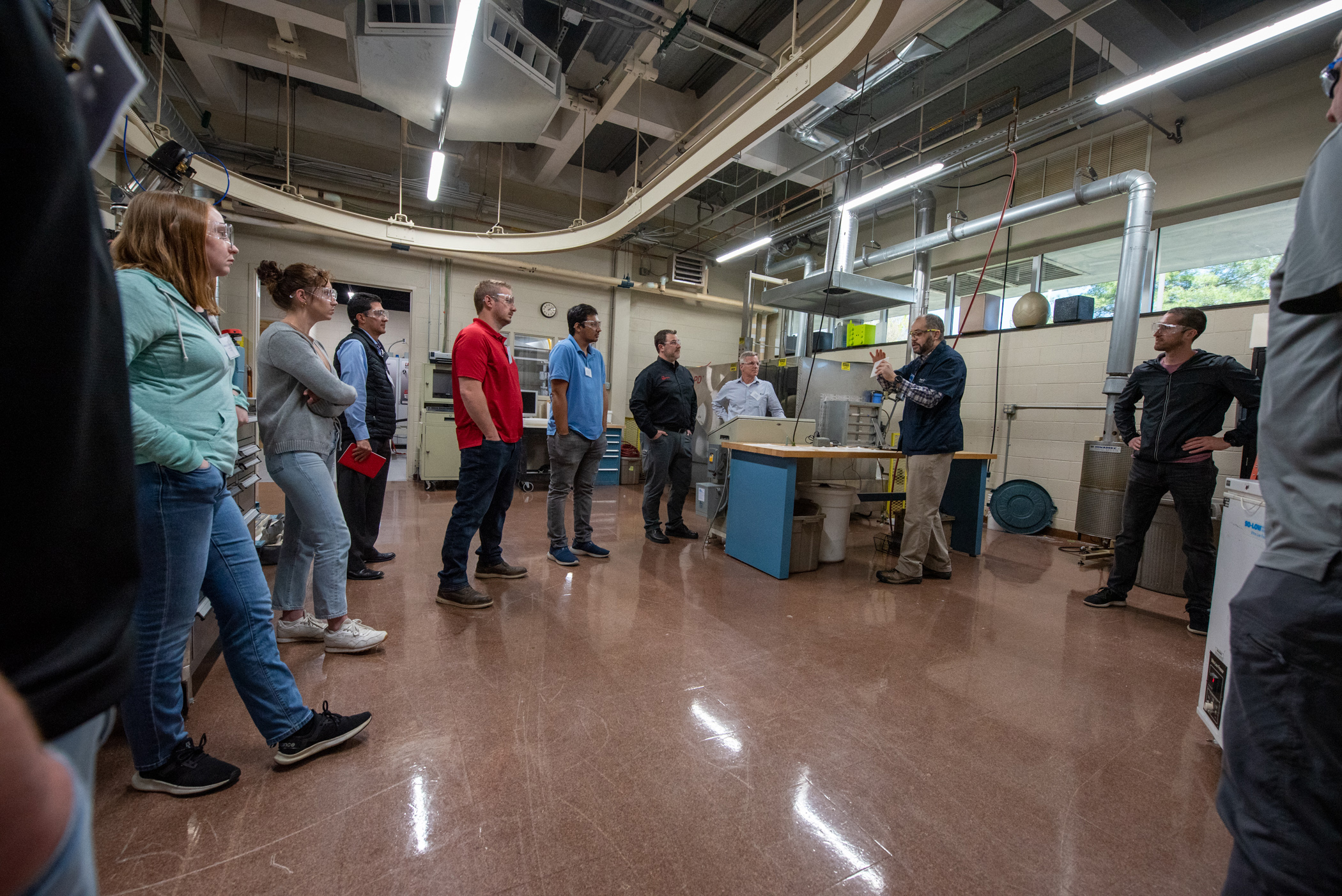 people standing in a large workshop area
