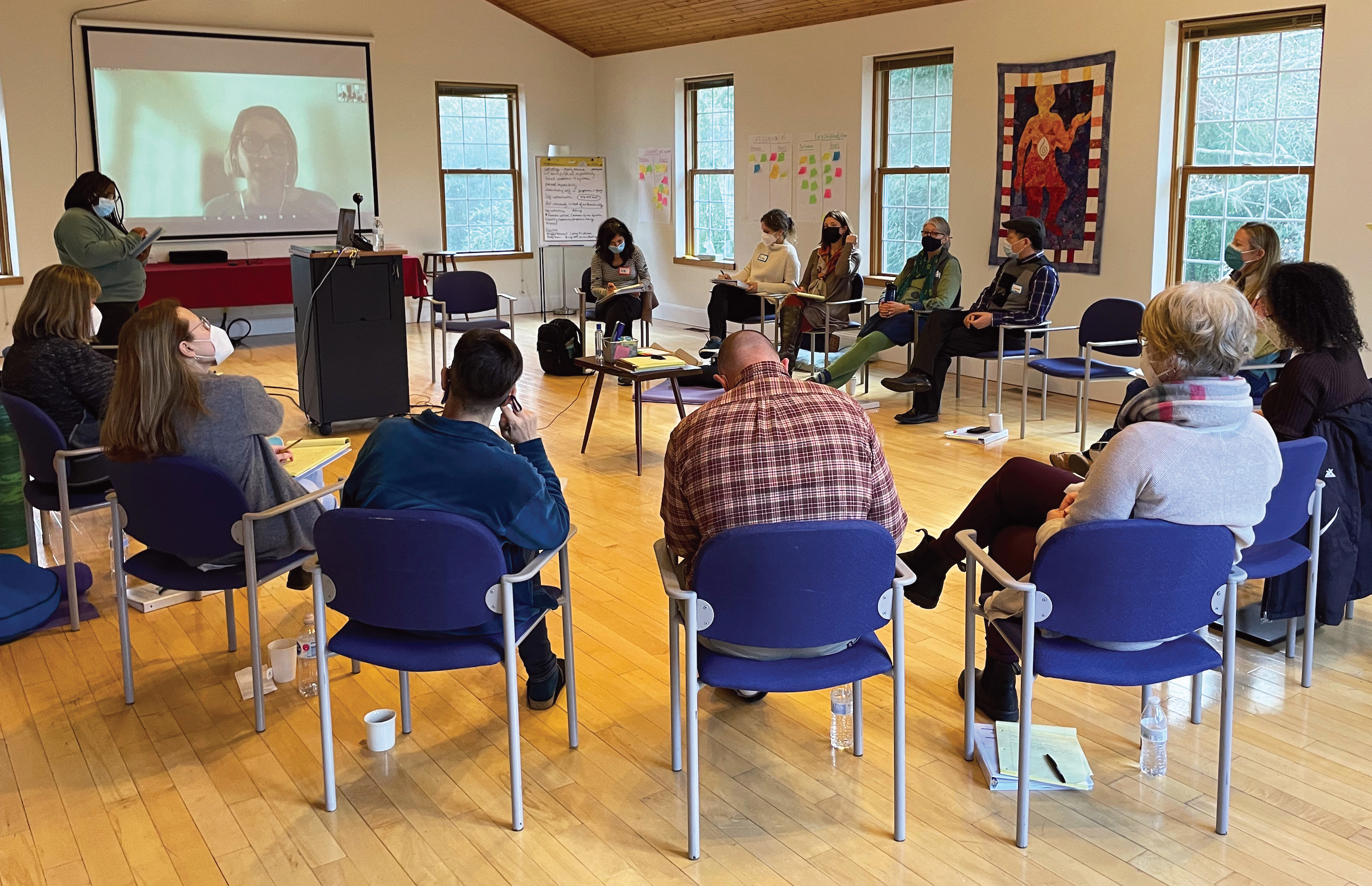 A group of people sitting in chairs assembled in a circle.