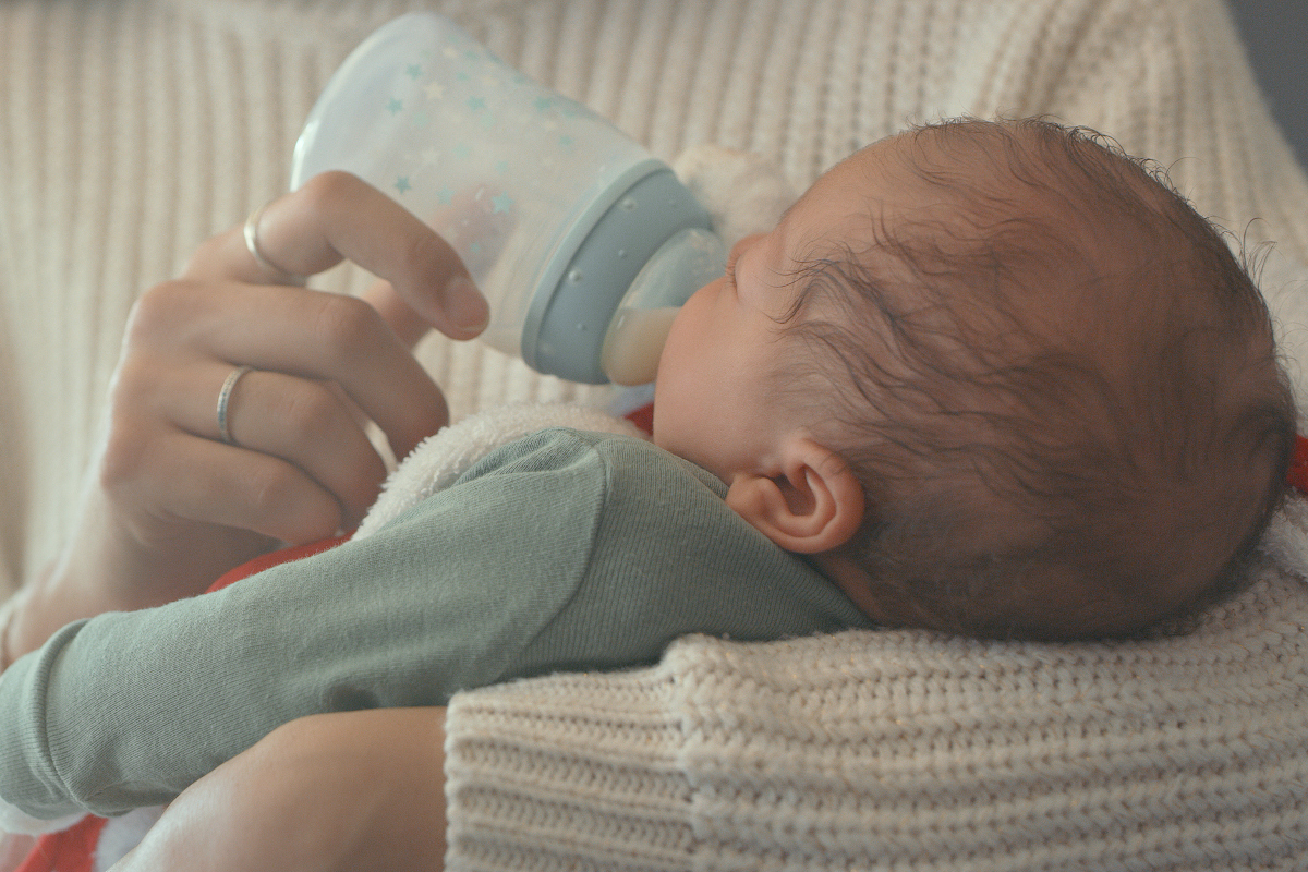 A mother feeds her newborn son.