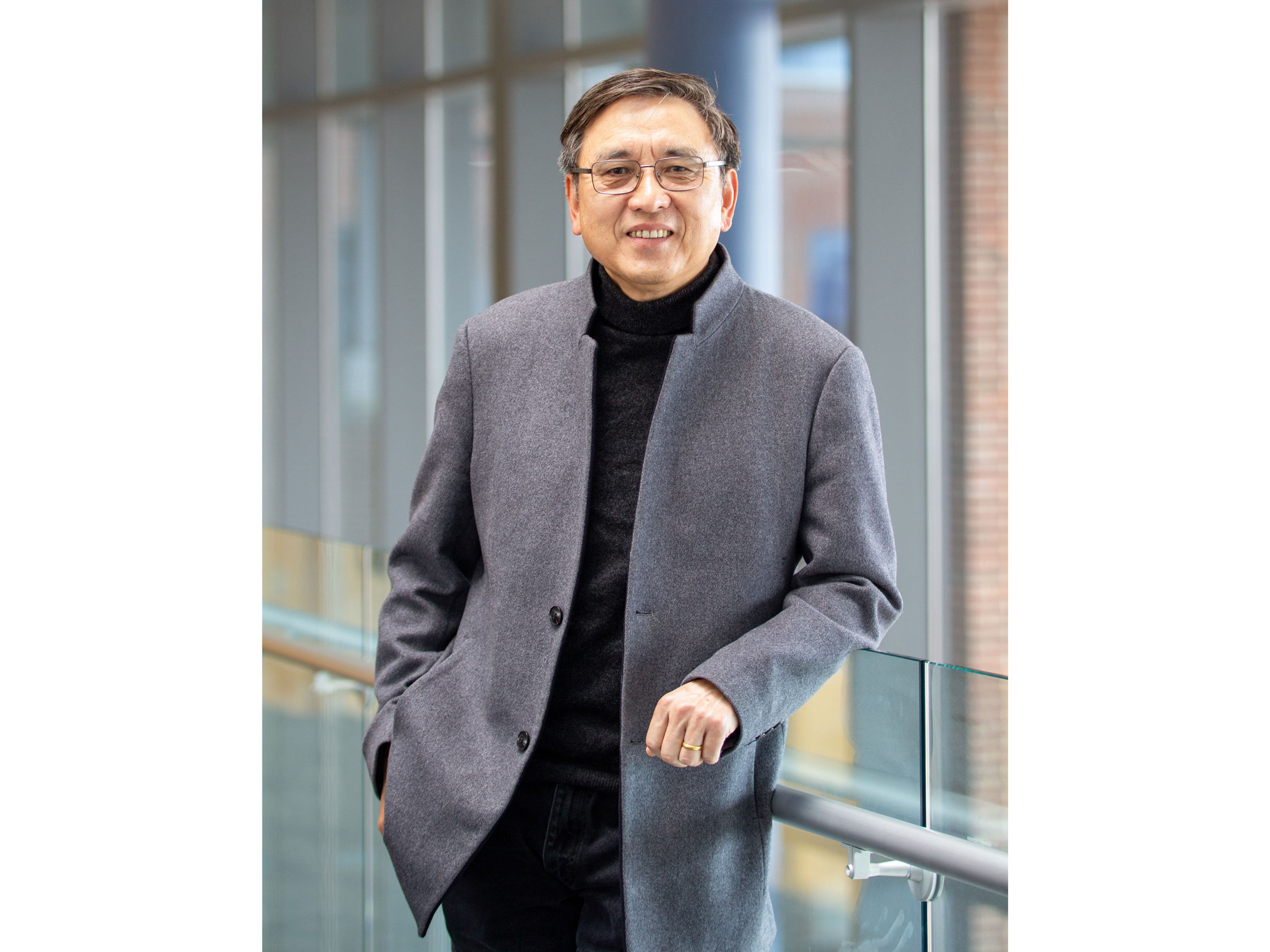 Jinchao Xu wearing suit in front of windows