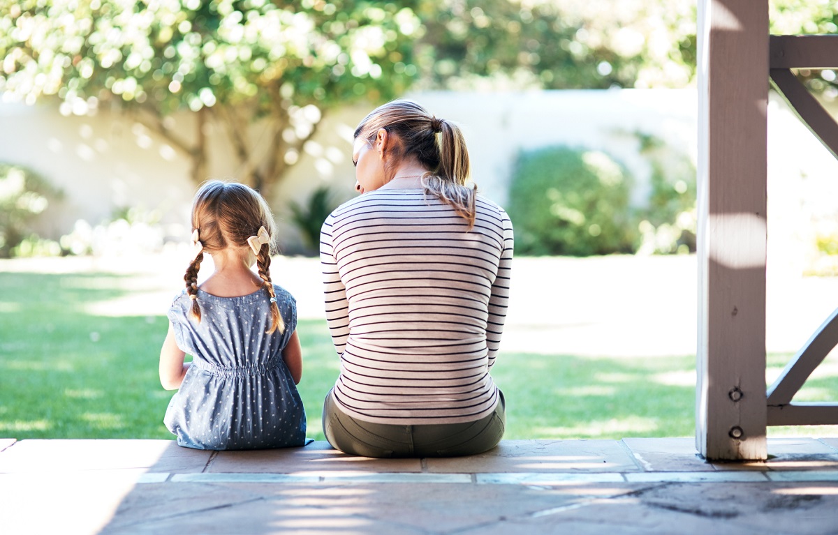 Rearview shot of a young woman and her daughter having a conversation on the porch.