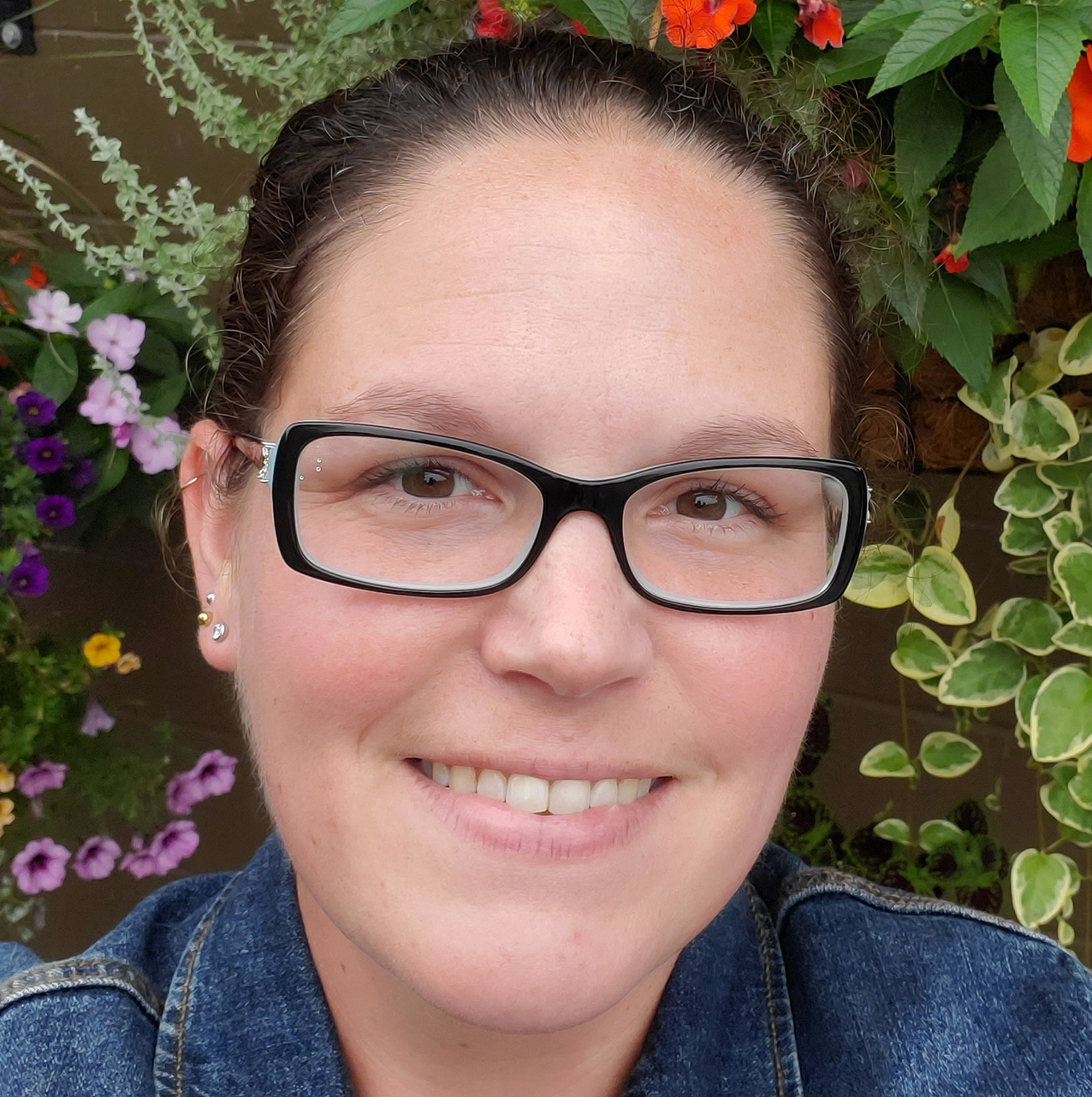 A headshot image of Rebecca Cornish with greenery and flowers in the background