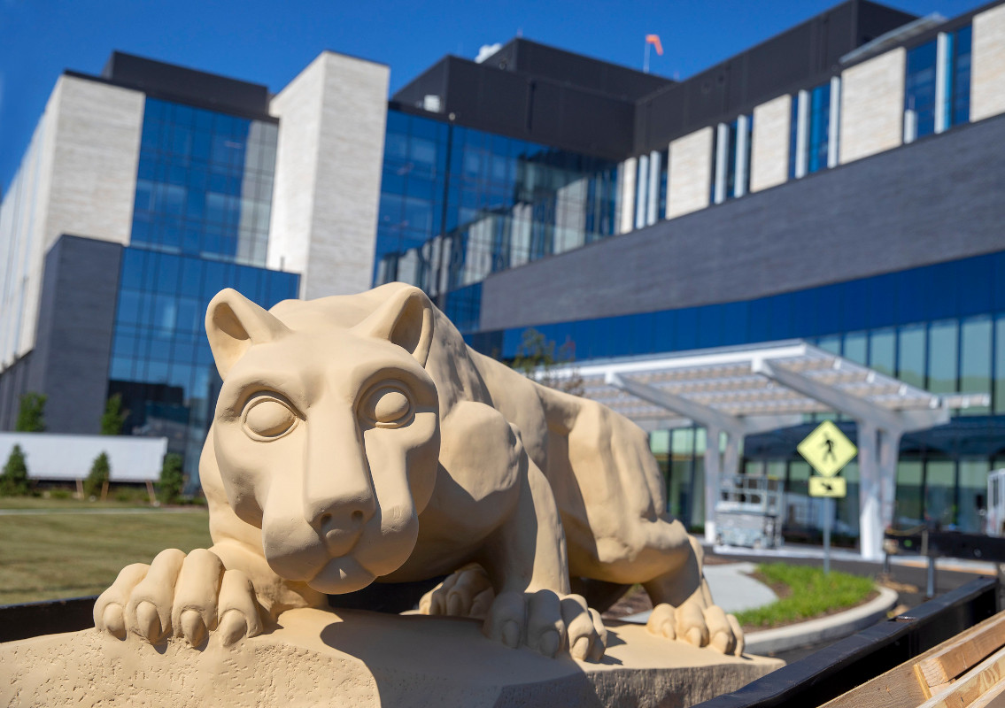 A photo of the Nittany Lion statue in front of a hospital