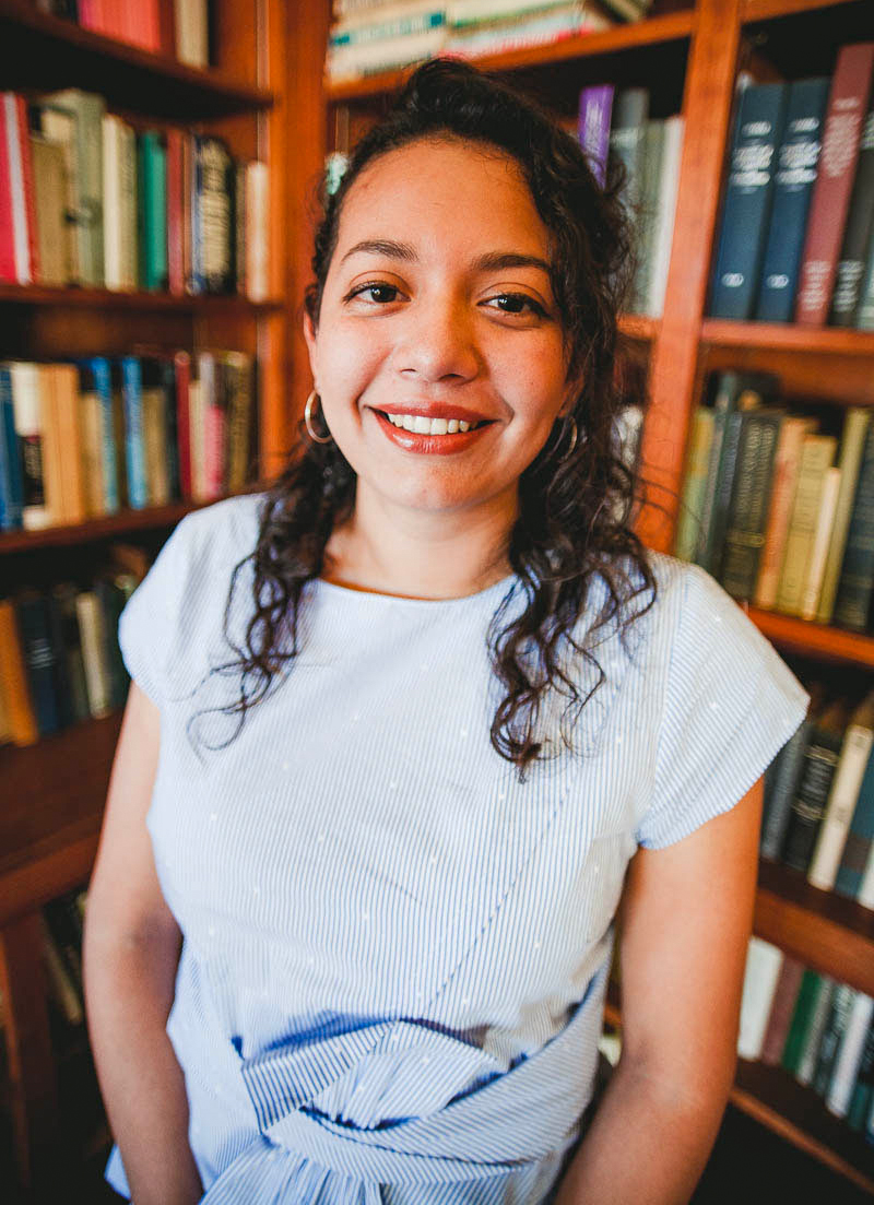 Portrait of woman standing in front of bookshelves