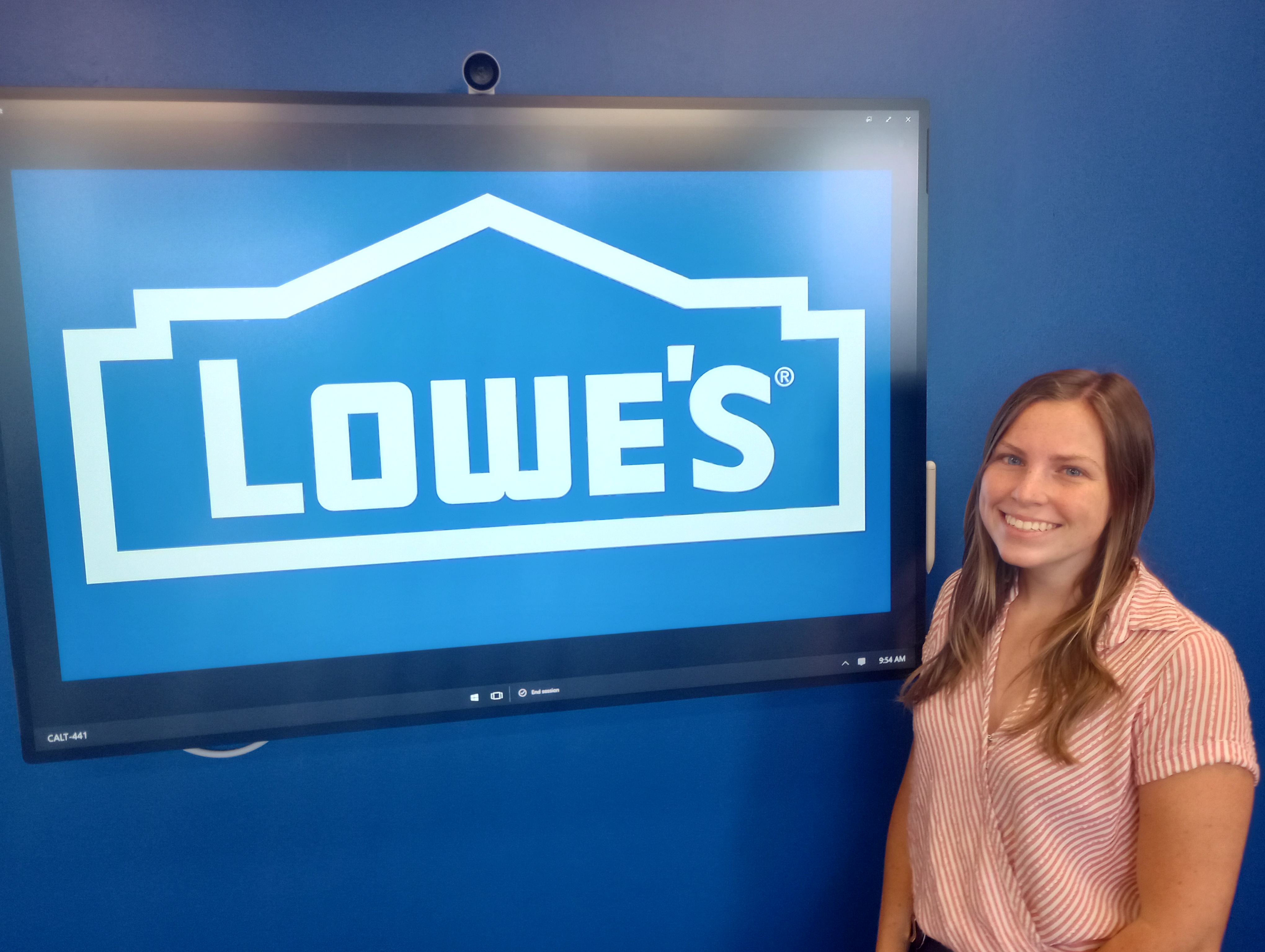 Hannah Kern stands in front of a Lowe's logo