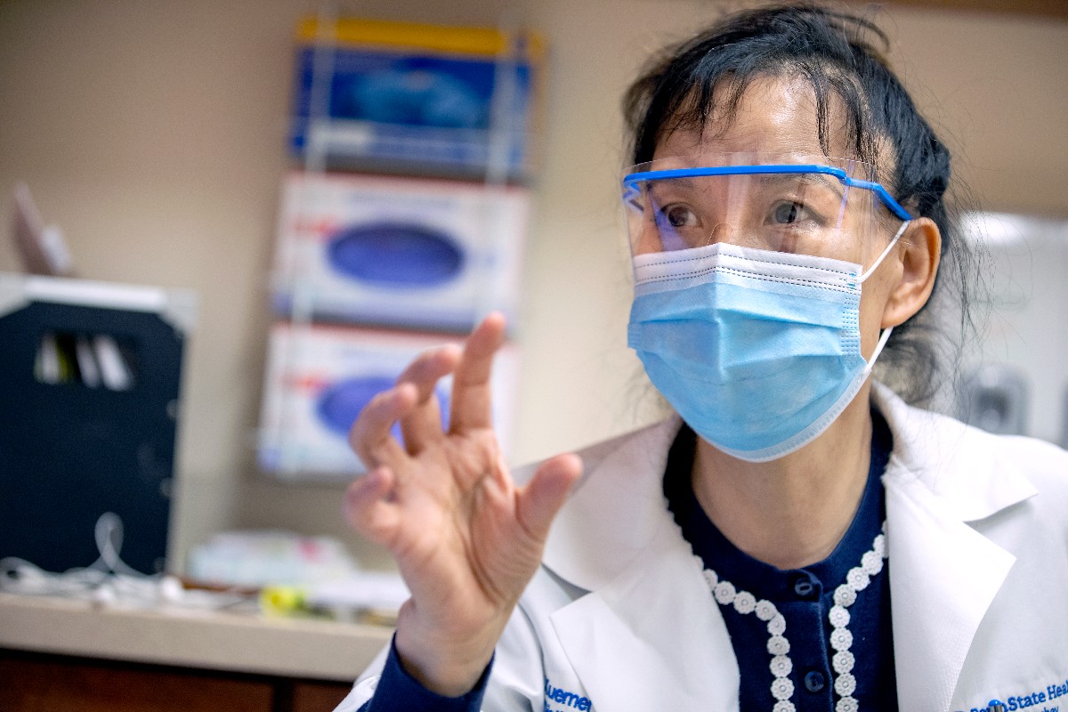 Dr. Xuemei Huang talks with a patient at Penn State Health Milton S. Hershey Medical Center.