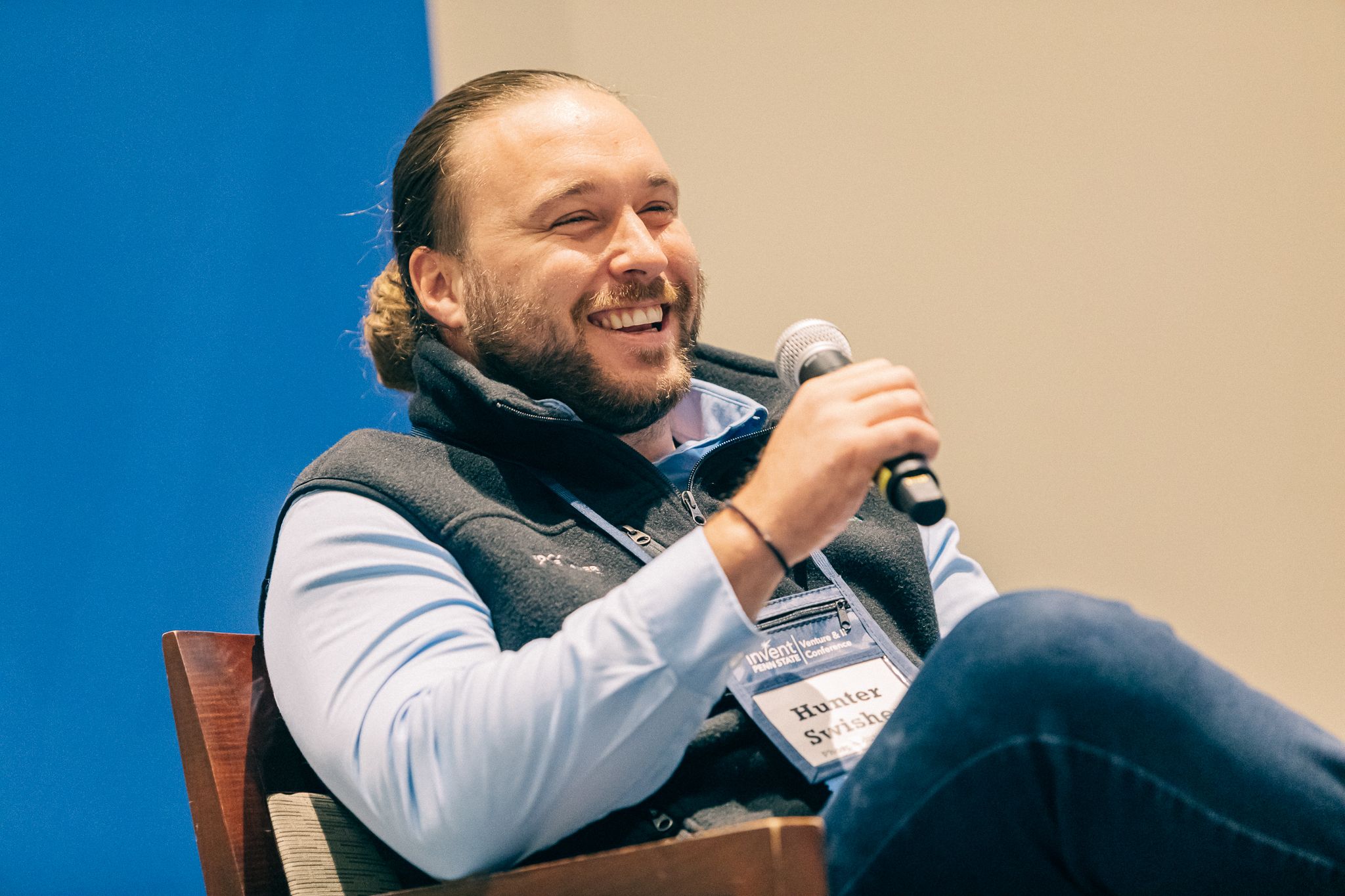 Hunter Swisher holding a microphone and smiling while speaking.