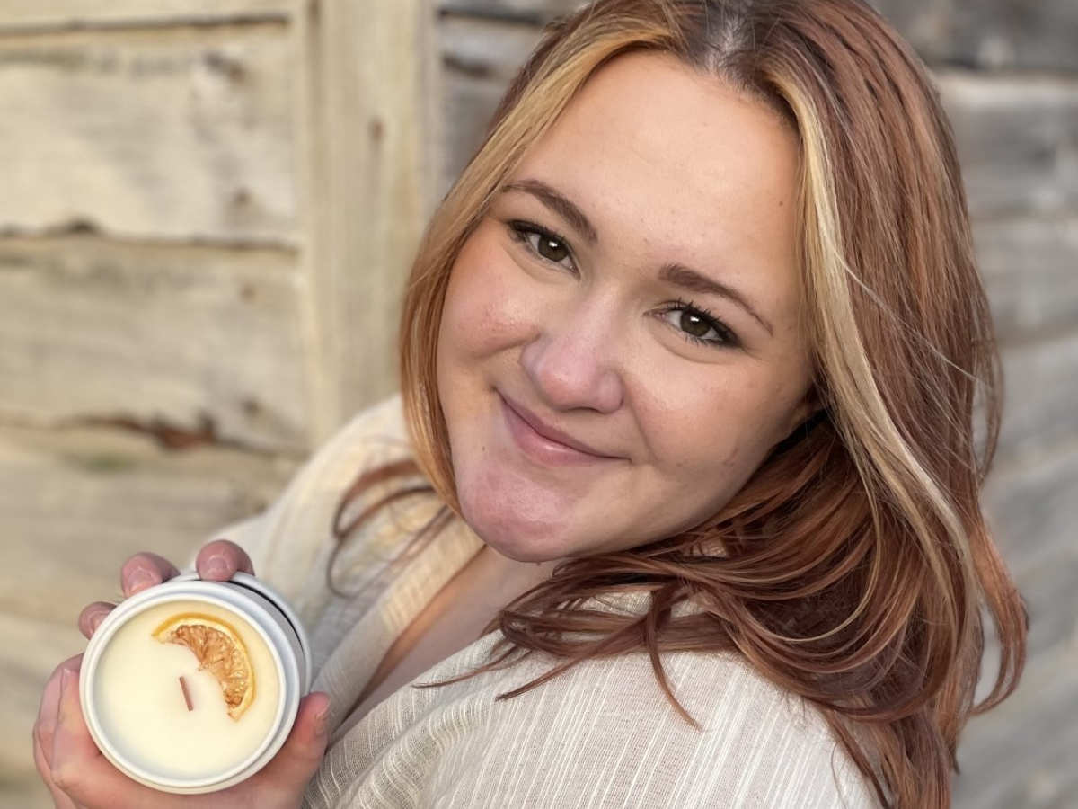 Student Kelsey Lauer poses with one of her hand-poured candles