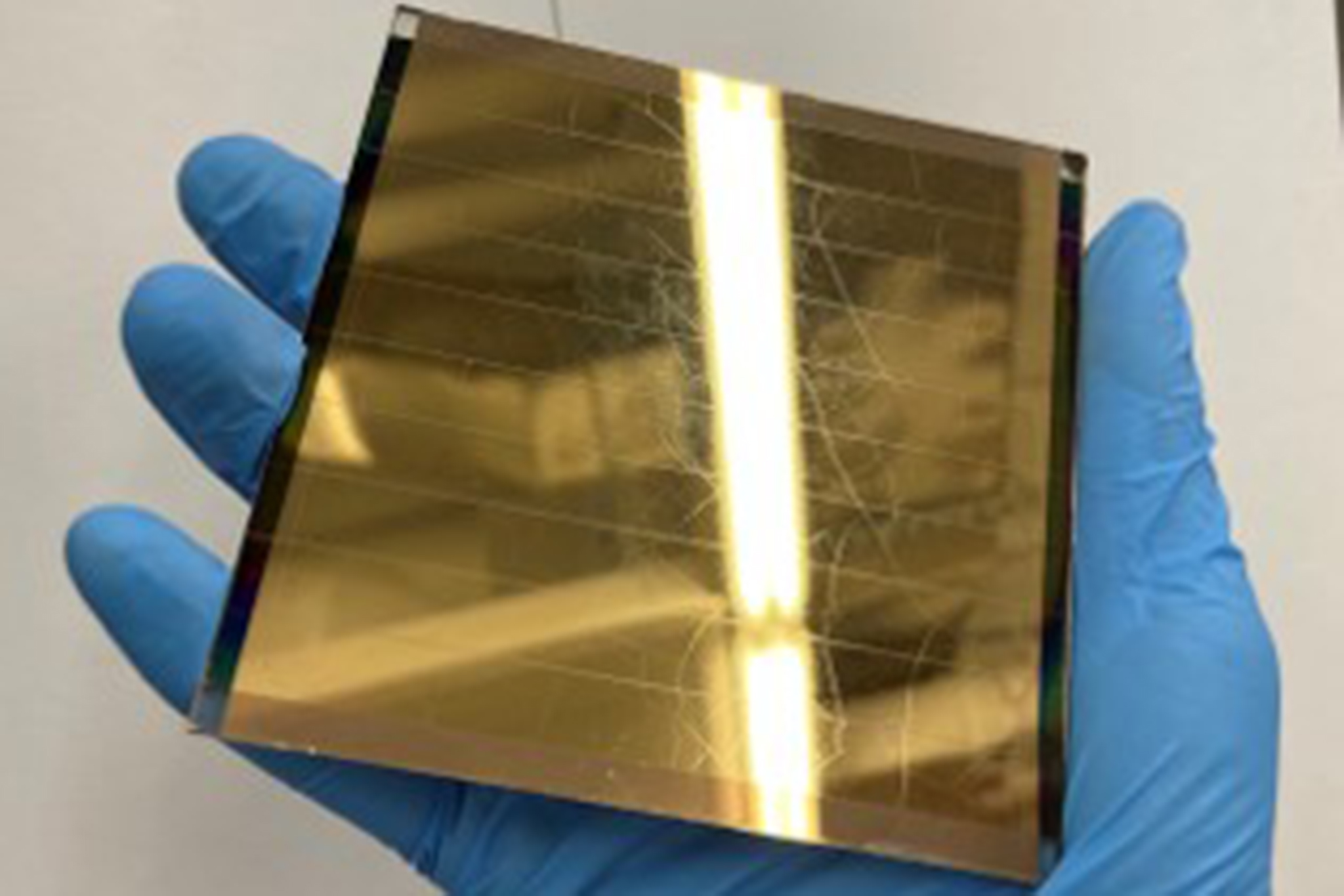 A researcher holds a perovskite solar module  