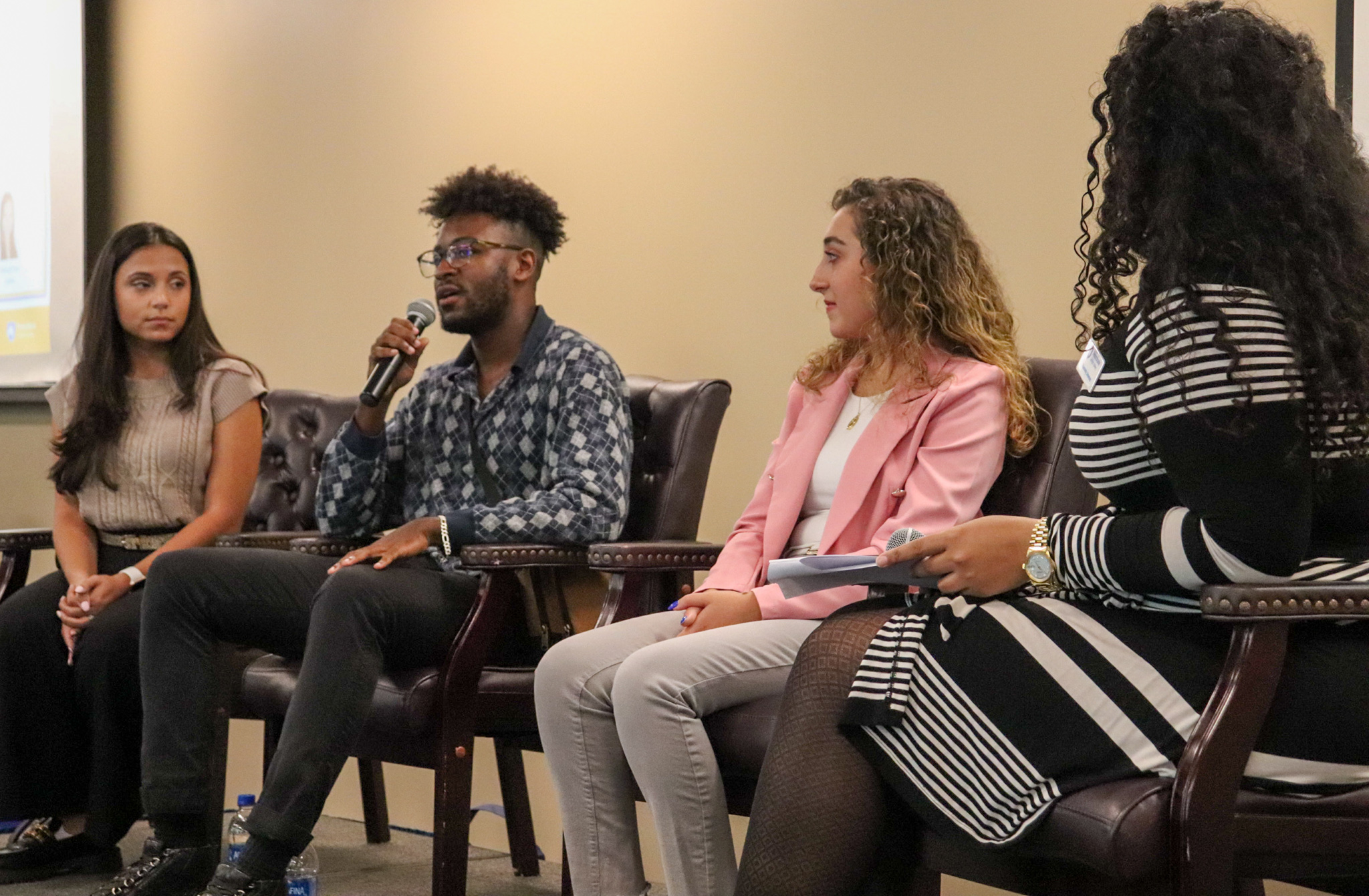 Three students on stage in panel setting