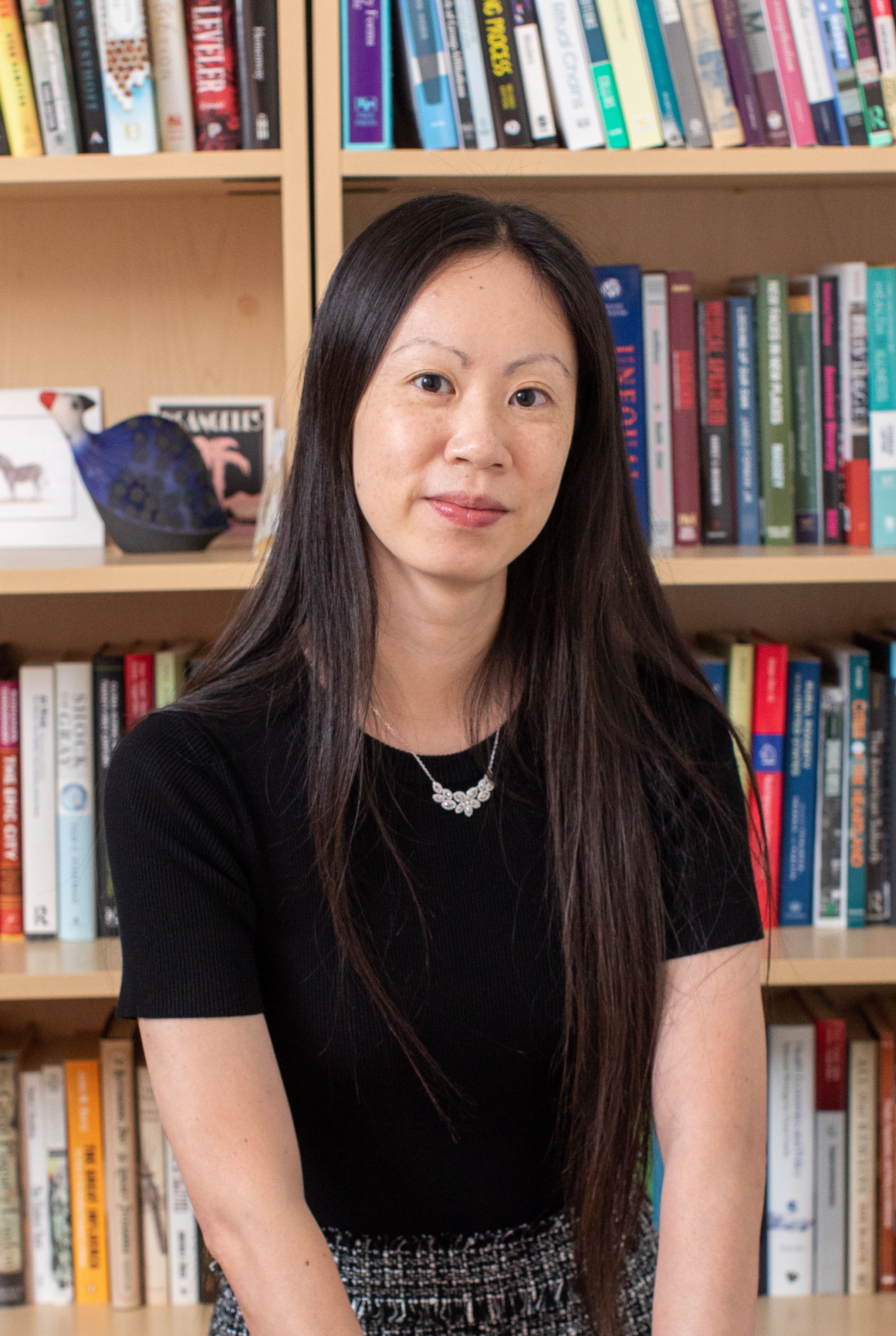 Jessica Ho headshot in black shirt with long black hair