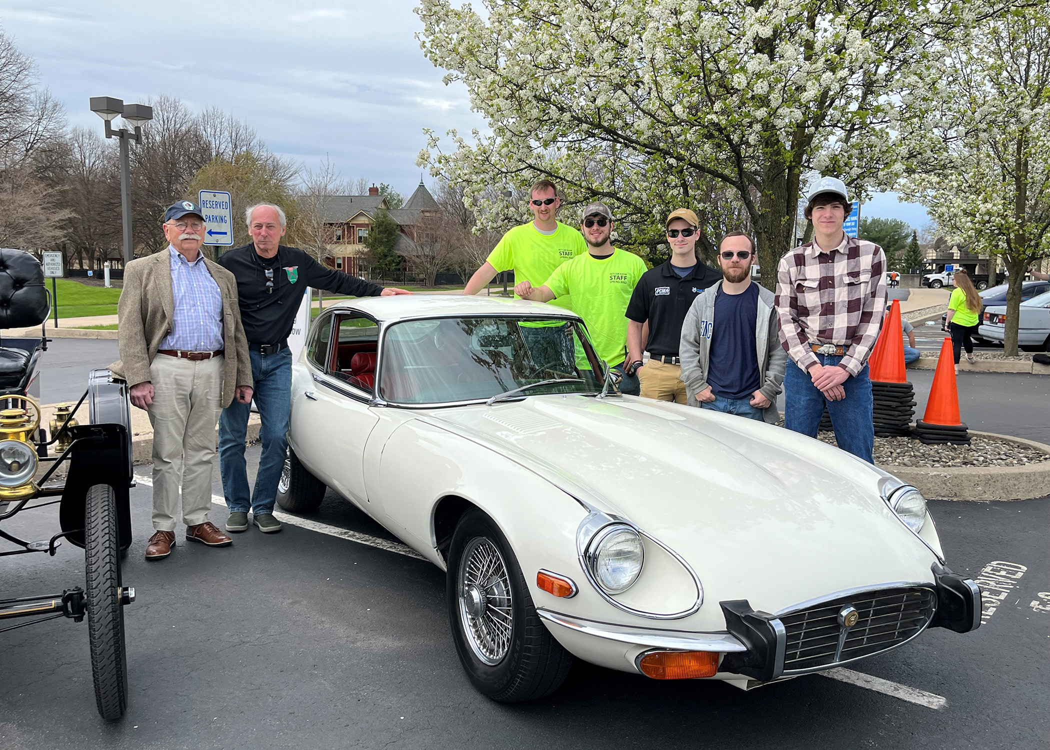 Students surrounding 1973 E-series Jaguar after restoration work.