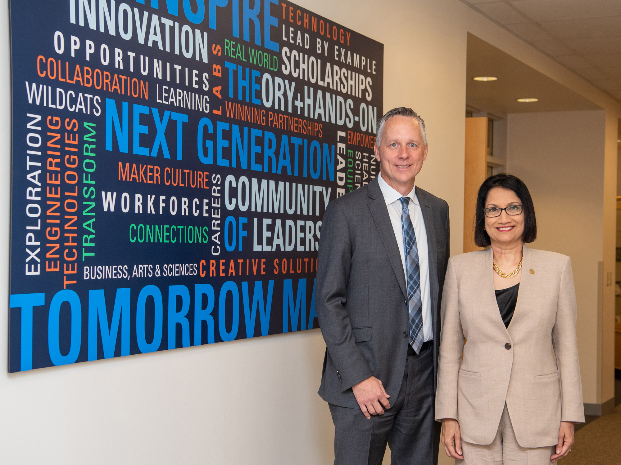 Penn College President Michael J. Reed and Penn State President Neeli Bendapudi stand next two a wall featuring a Penn College word cloud.