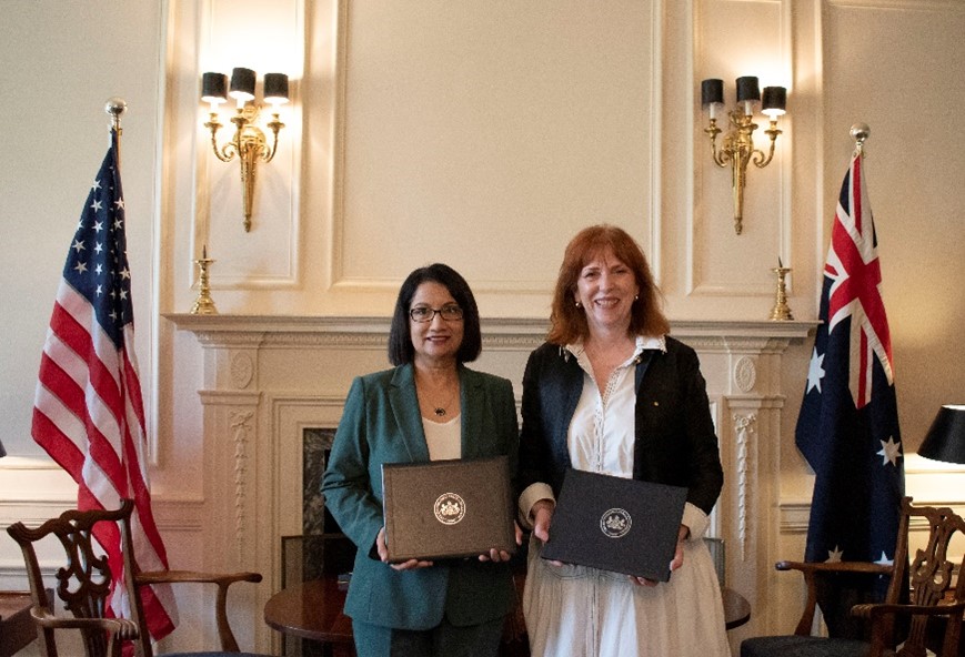 Two women posing with folders