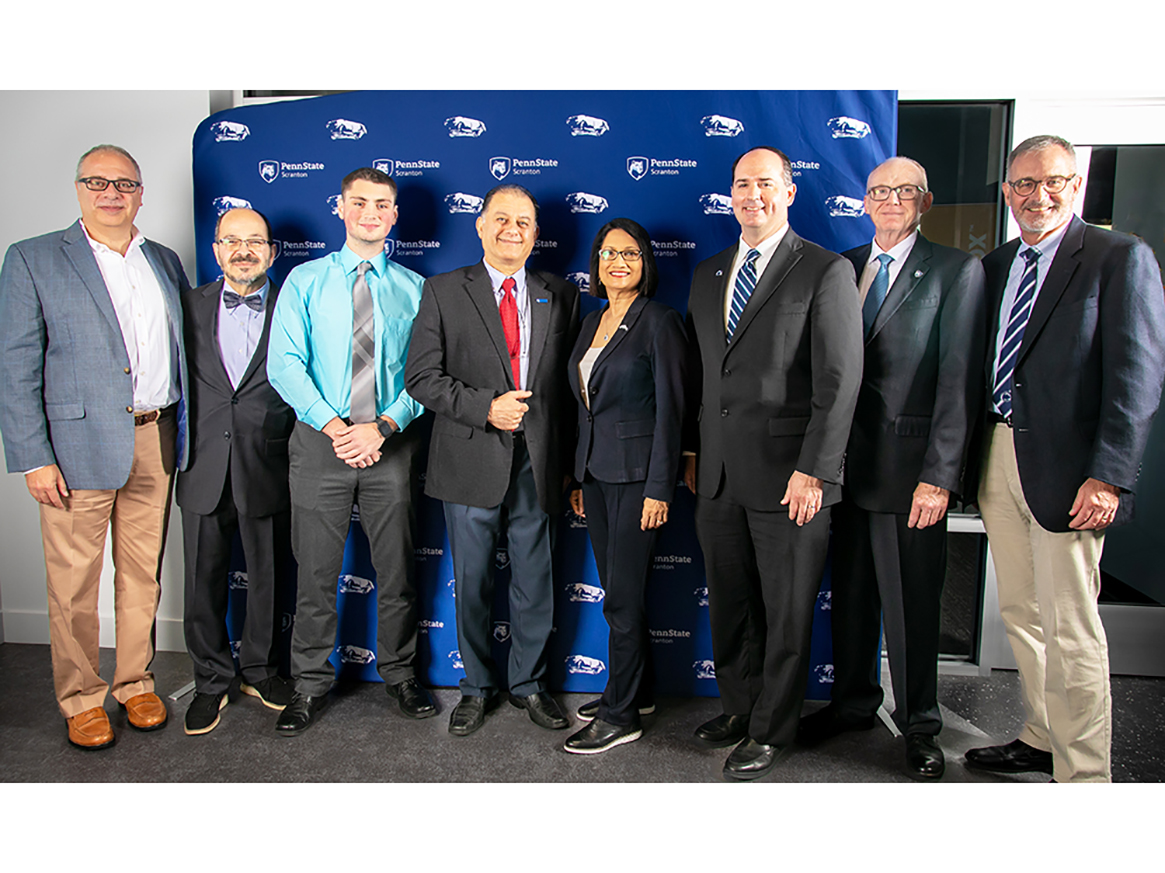 Group of University officials pose for a photo with Penn State Scranton banner backdrop