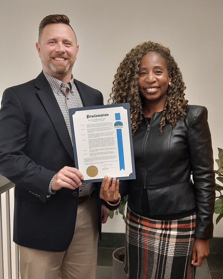 Two people stand with a proclamation. 
