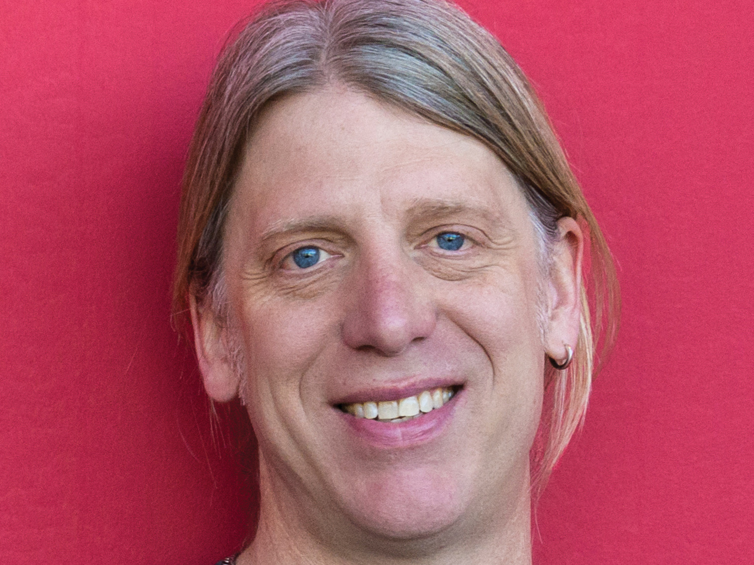 A headshot of Timothy Yarrington against a red background