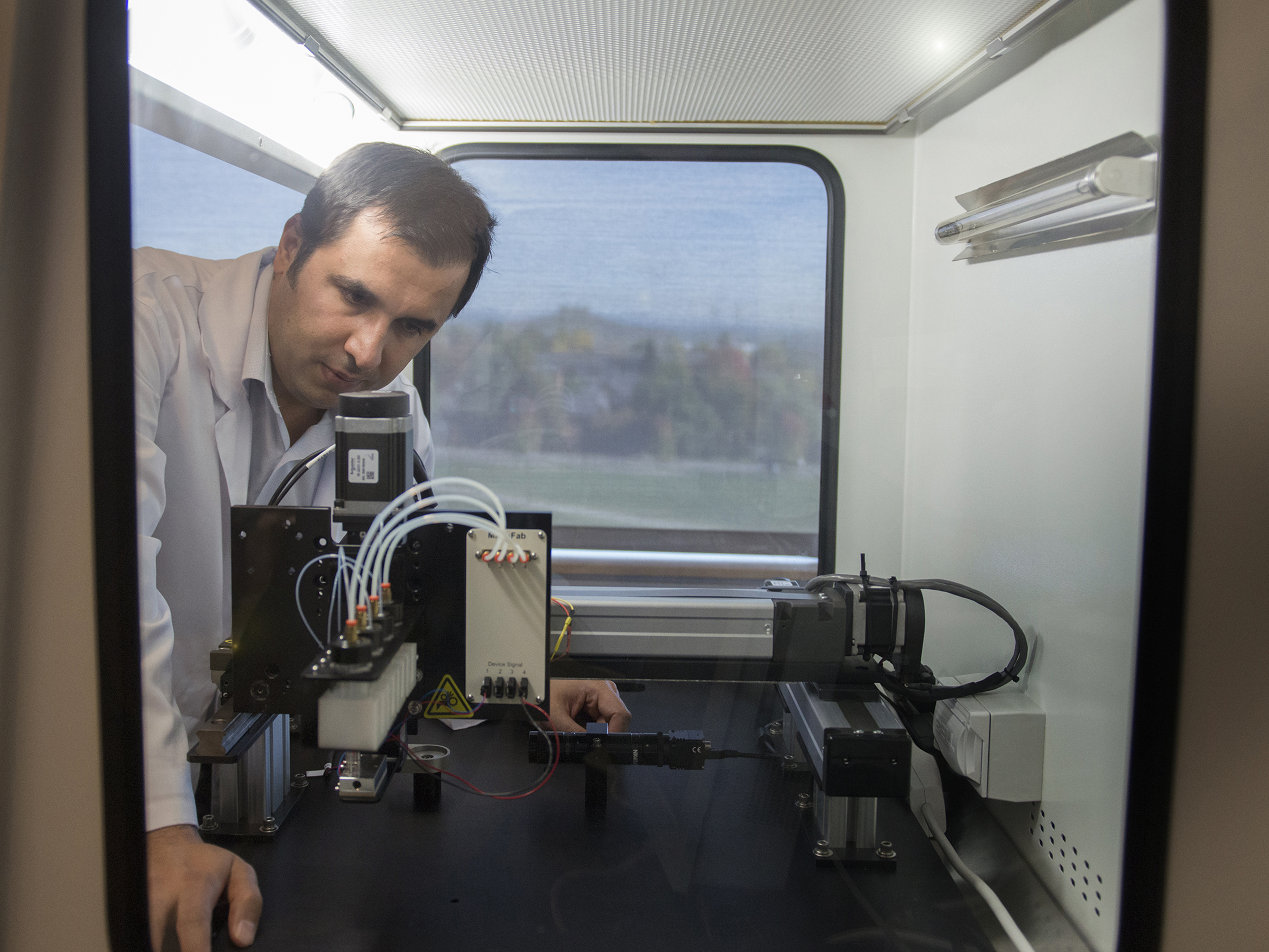 researcher works with bioprinting instrument in lab 